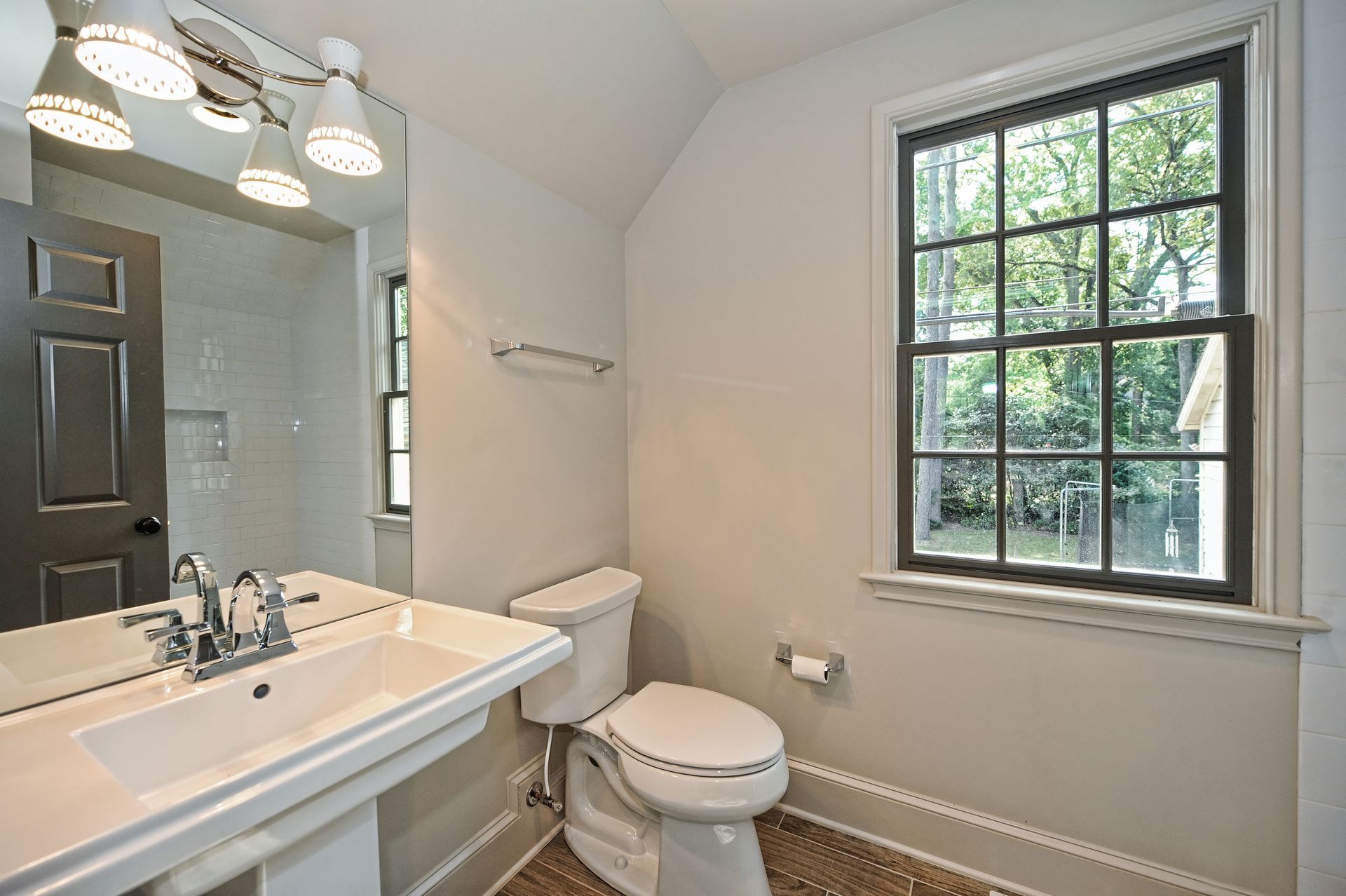 A bathroom with a toilet a sink and a window