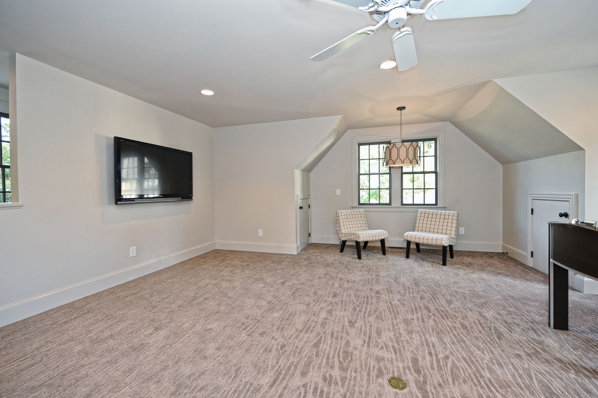 There is a ceiling fan in the room and a flat screen tv on the wall.