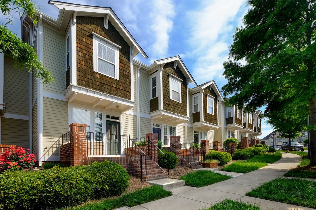 a row of houses are lined up next to each other on a sunny day .