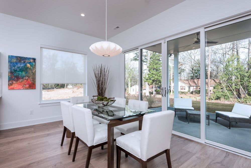 A dining room with a table and chairs and sliding glass doors.