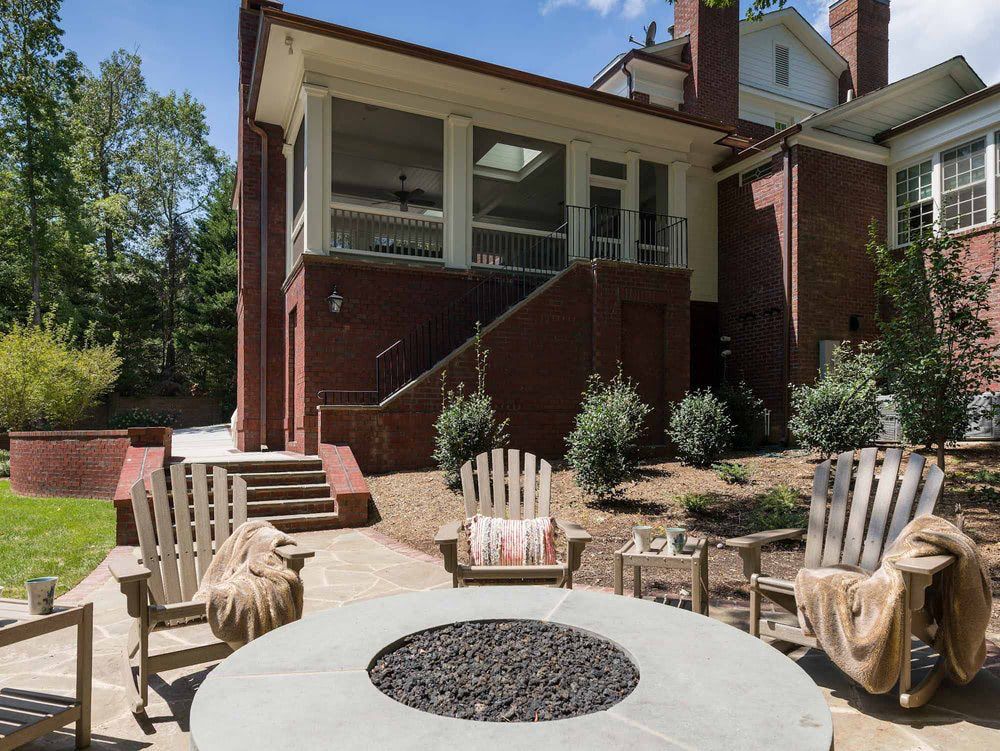A large brick house with a fire pit in front of it