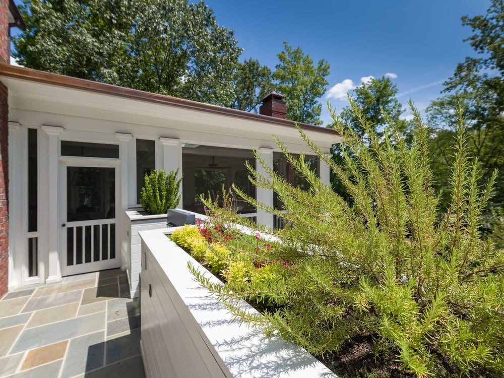 A house with a screened in porch and trees in the background
