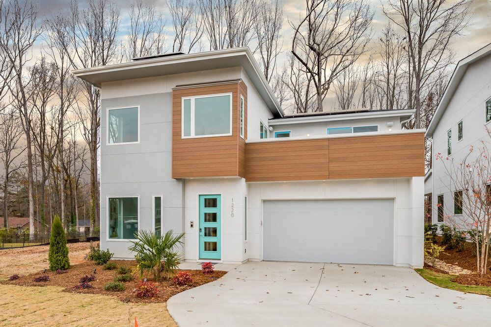 A modern house with a white garage door and a blue door.