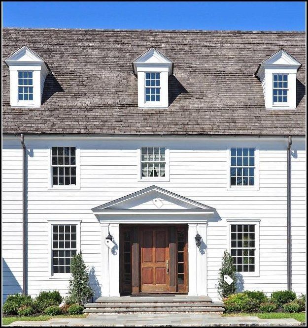 a large white house with a wooden door and windows