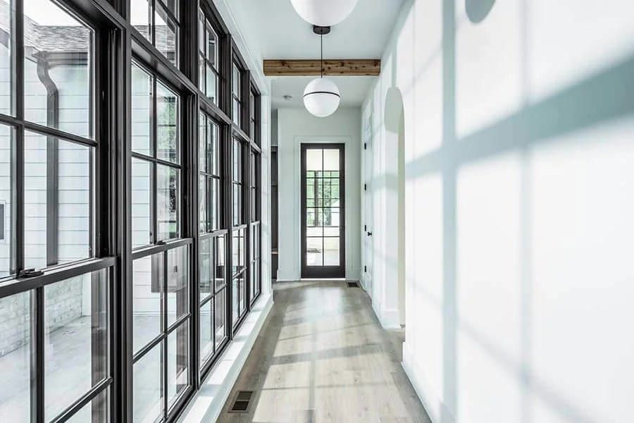 A hallway with a lot of windows and a door.