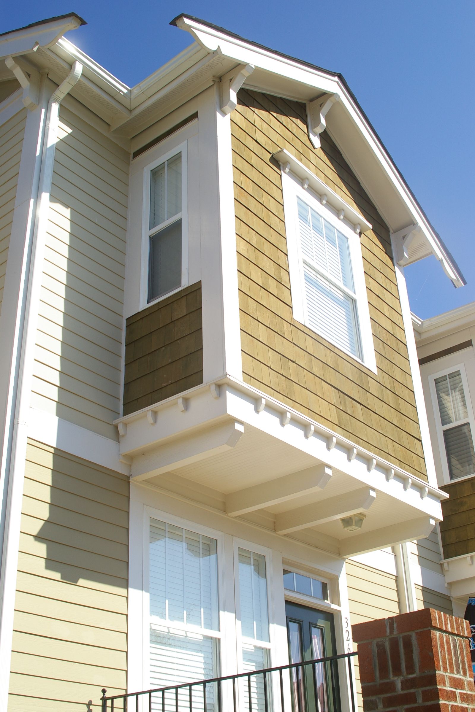 A house with a balcony and a blue sky in the background