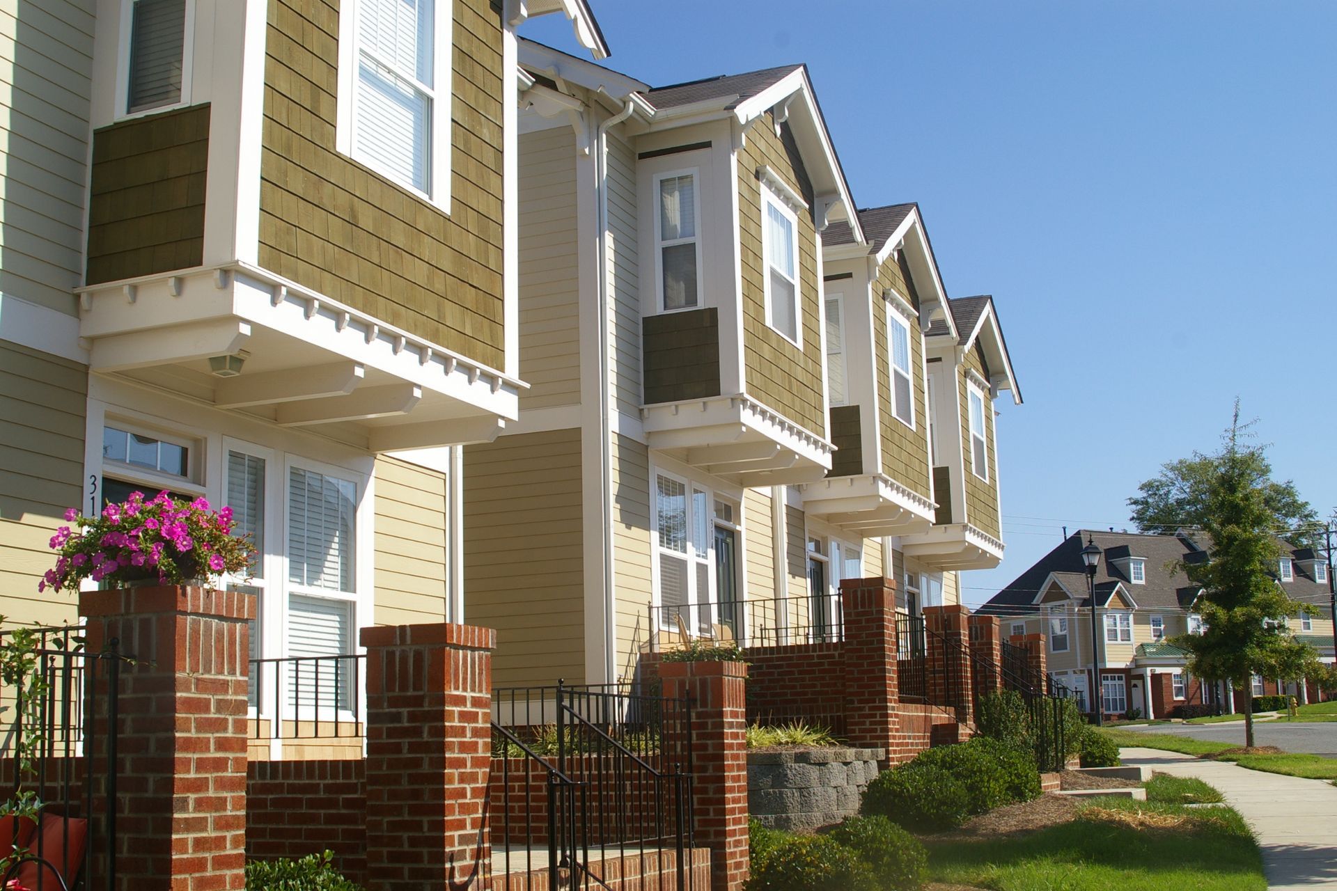 A row of houses with a brick fence in front of them