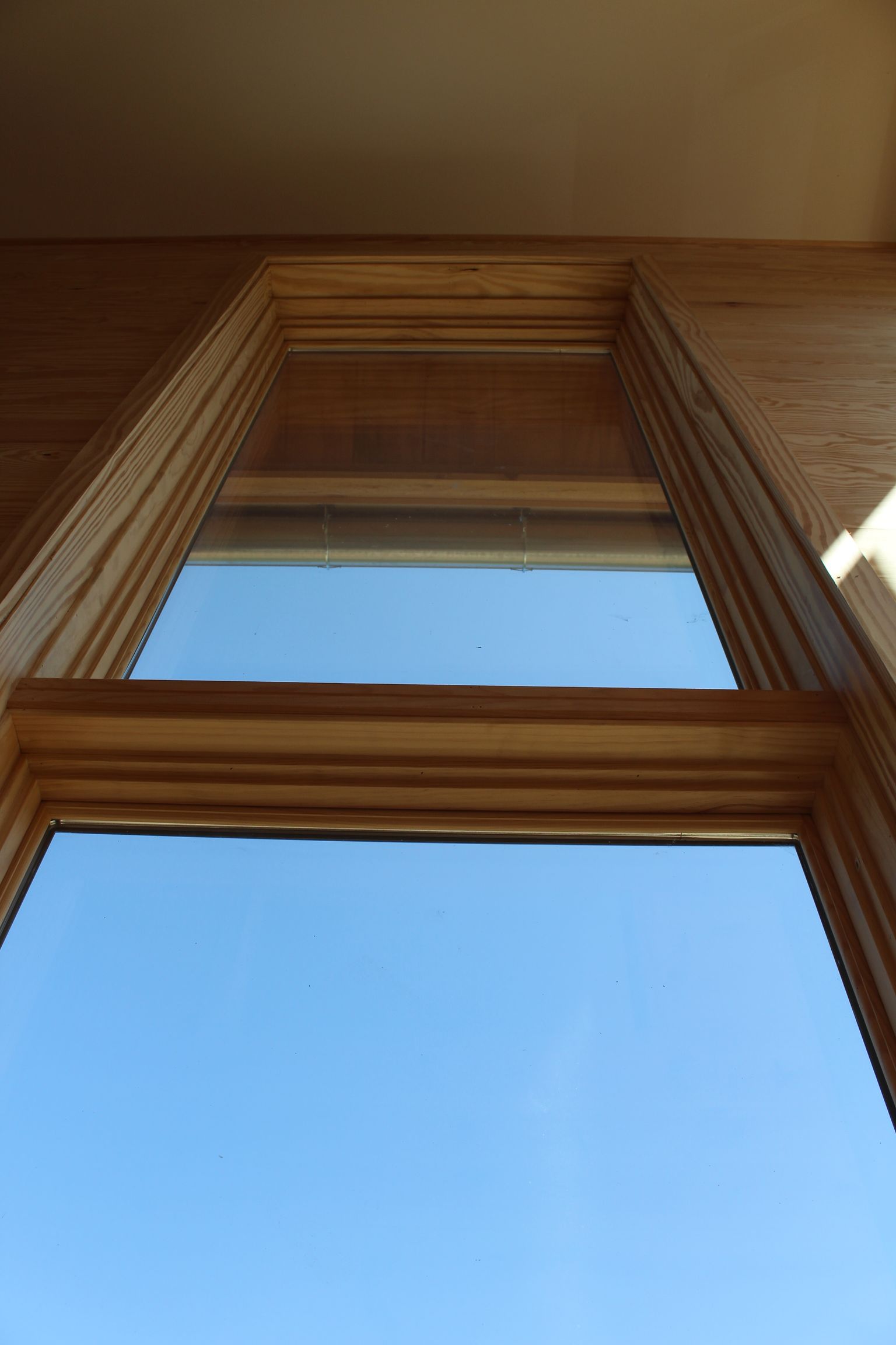 Looking up at a window with a blue sky behind it.