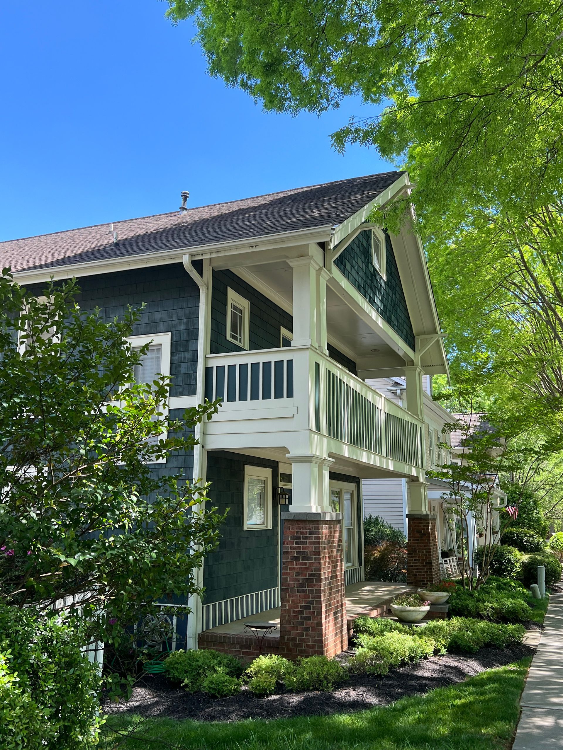 A large house with a balcony and a blue sky in the background.