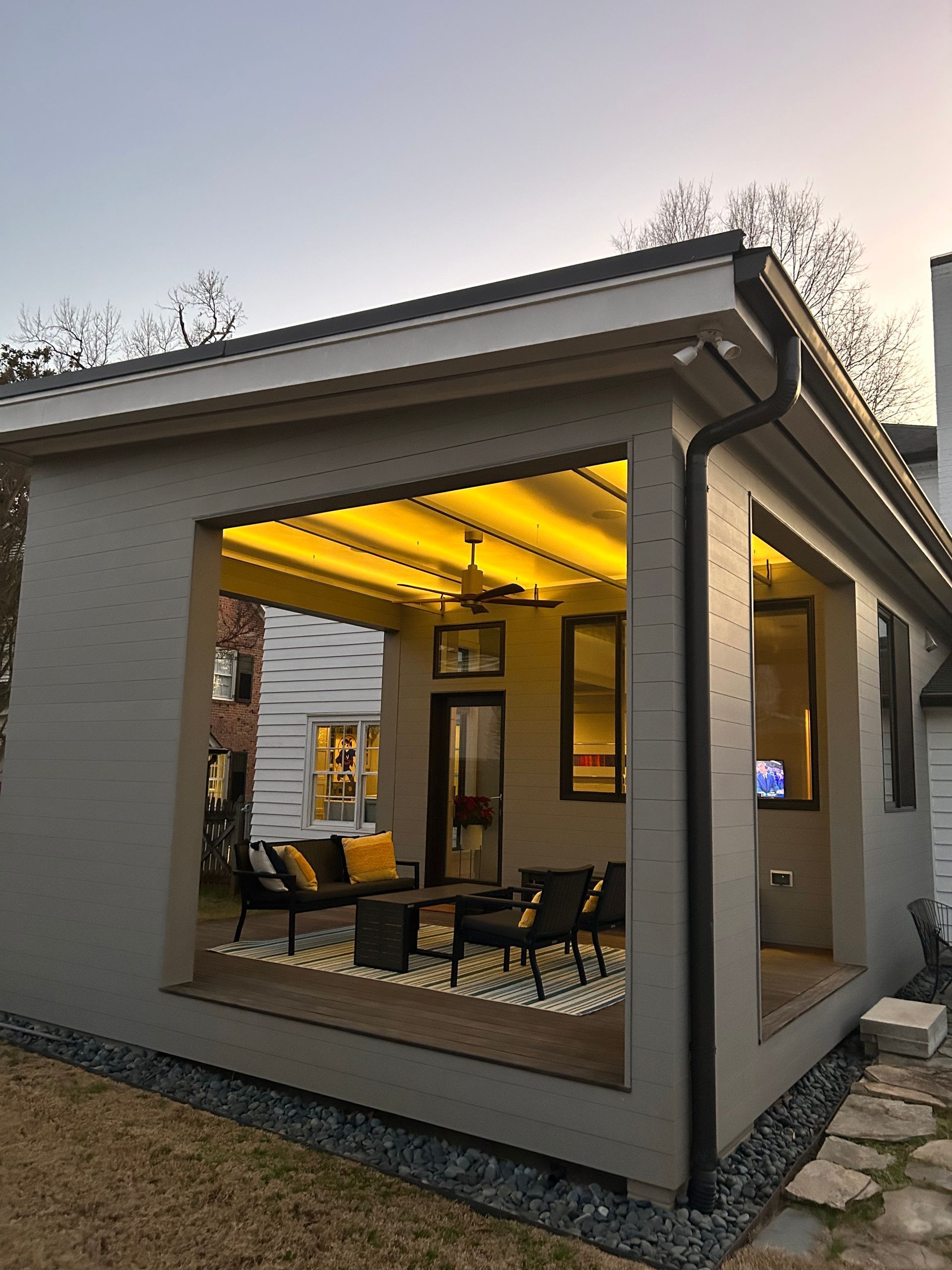 A house with a covered porch with a lot of furniture on it