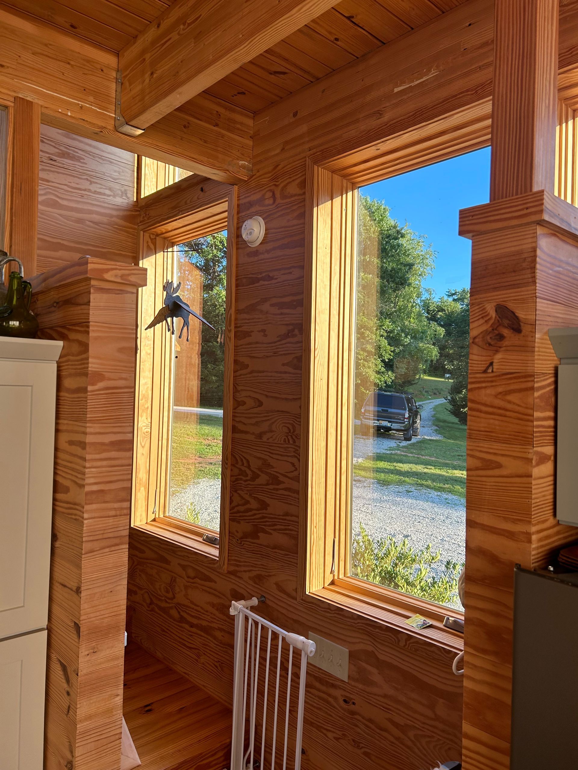 A wooden house with a lot of windows and a fence.