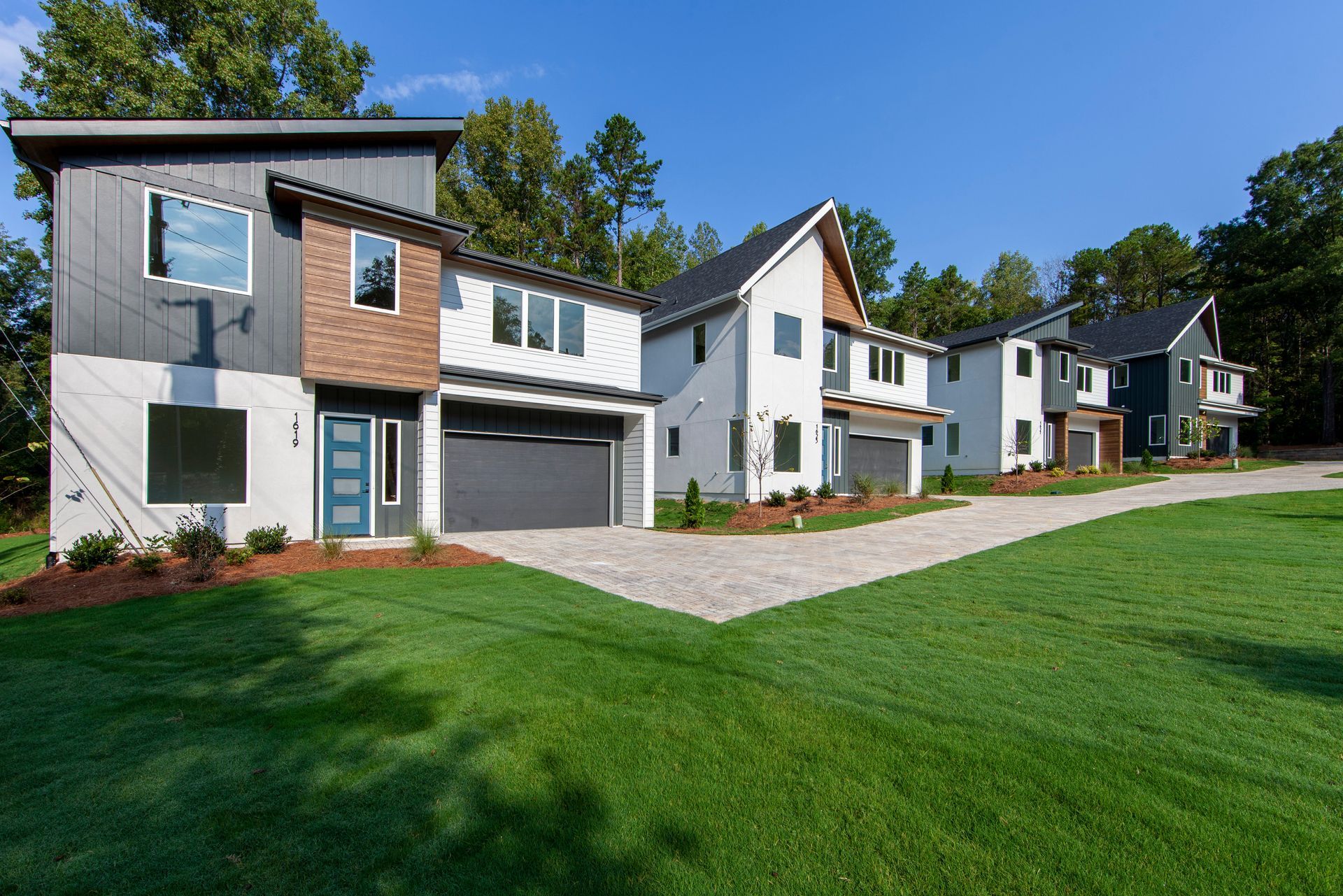 A row of houses sitting next to each other on a lush green lawn.
