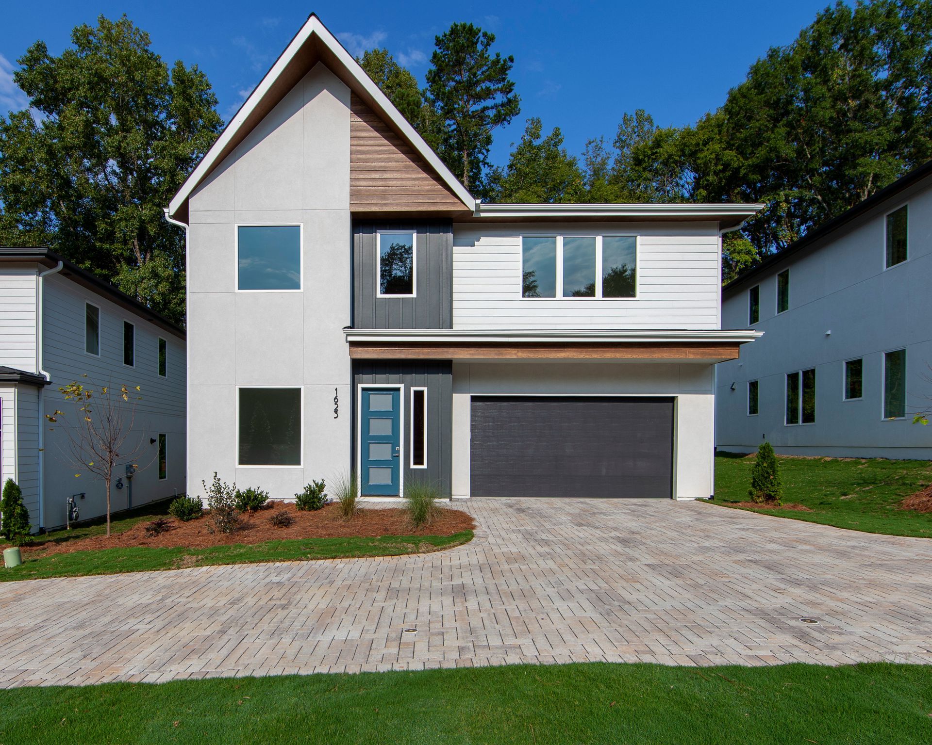 A modern white house with a black garage door