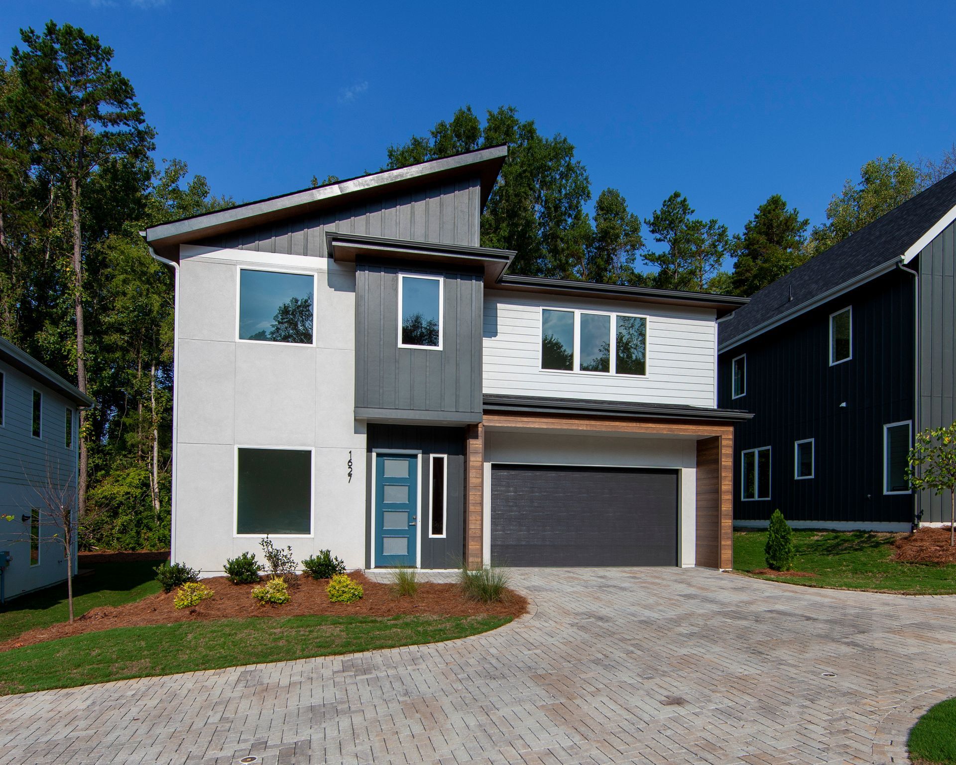 A modern house with a gray garage door and a blue door