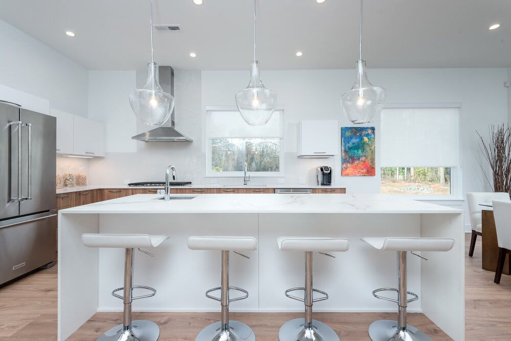 A kitchen with a large island and three bar stools.