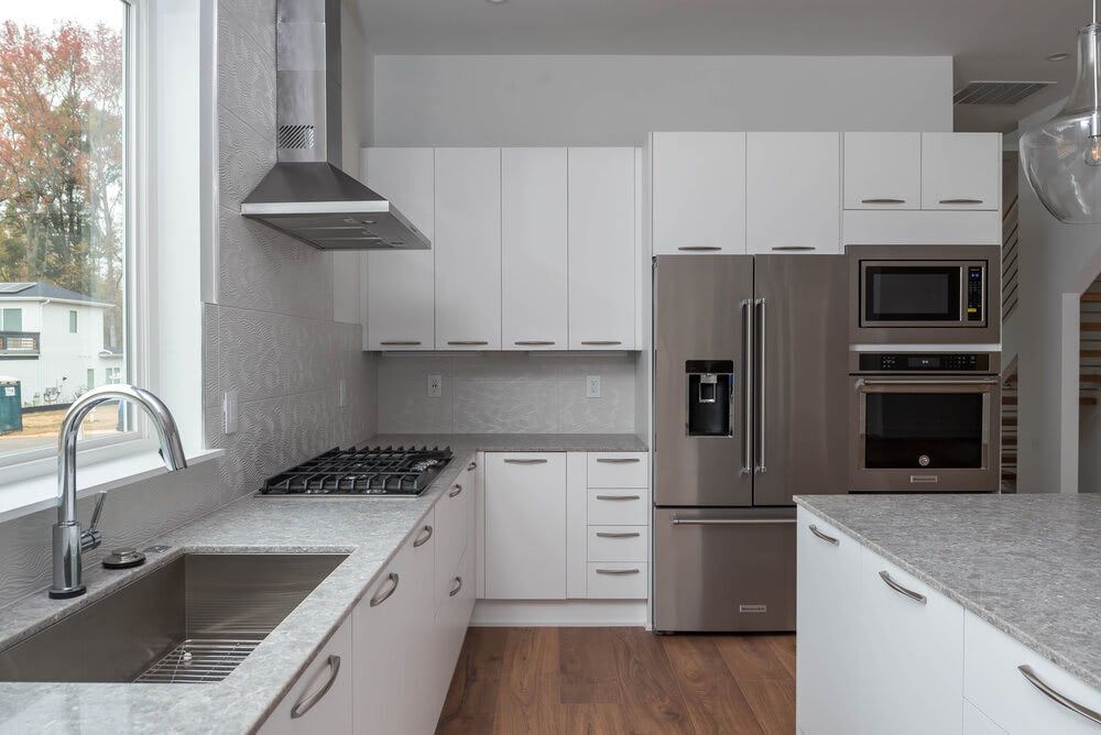 A kitchen with stainless steel appliances and white cabinets