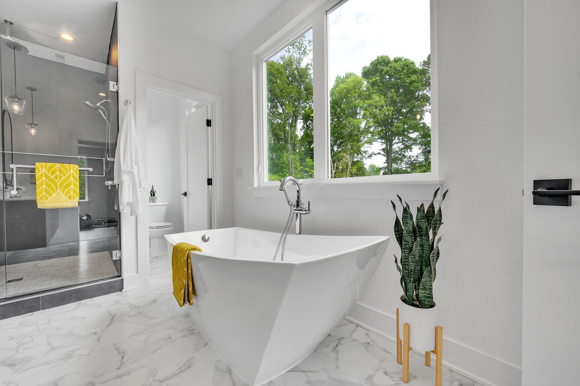 A bathroom with a tub , shower , and window.