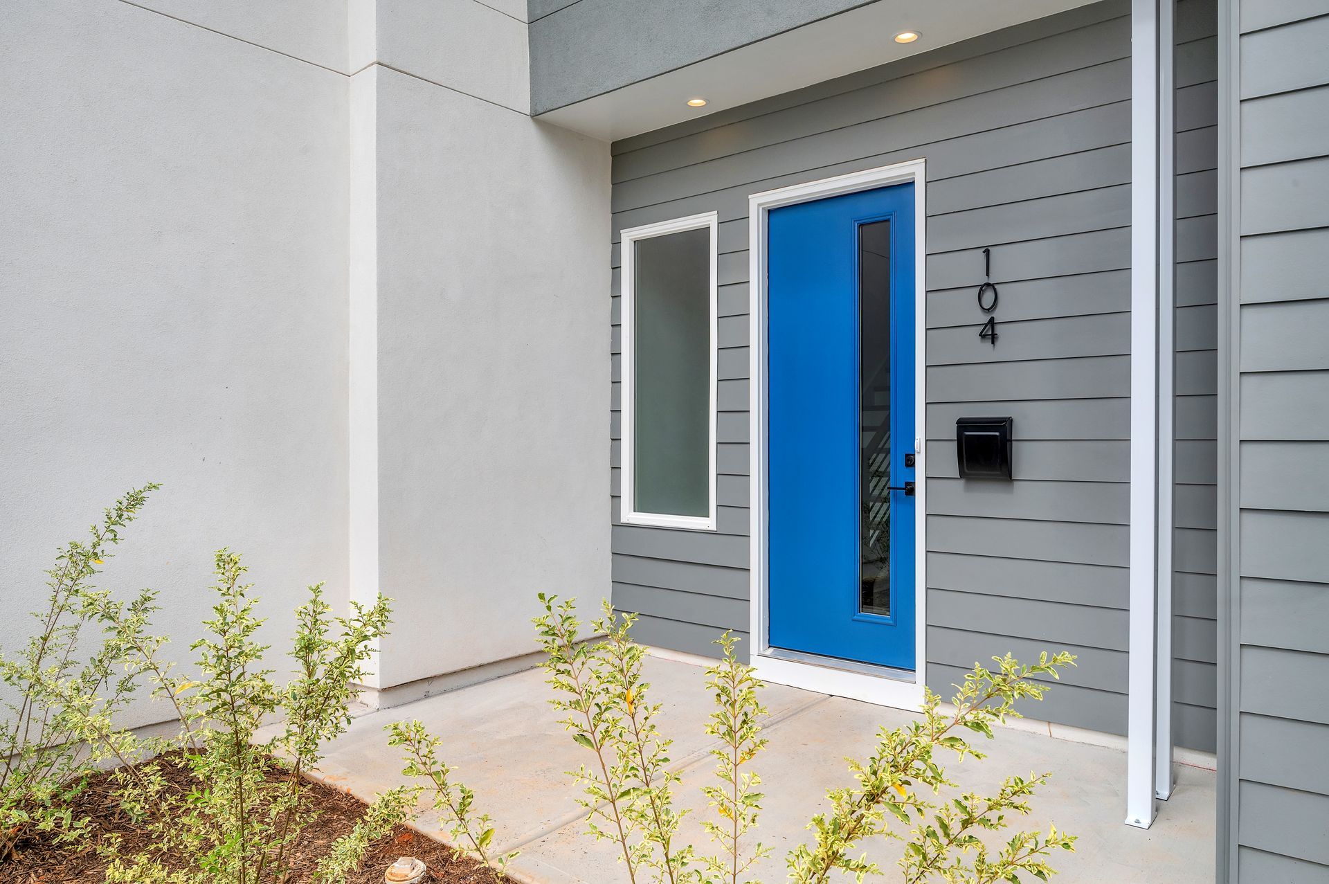 The front door of a house with a blue door and a mailbox
