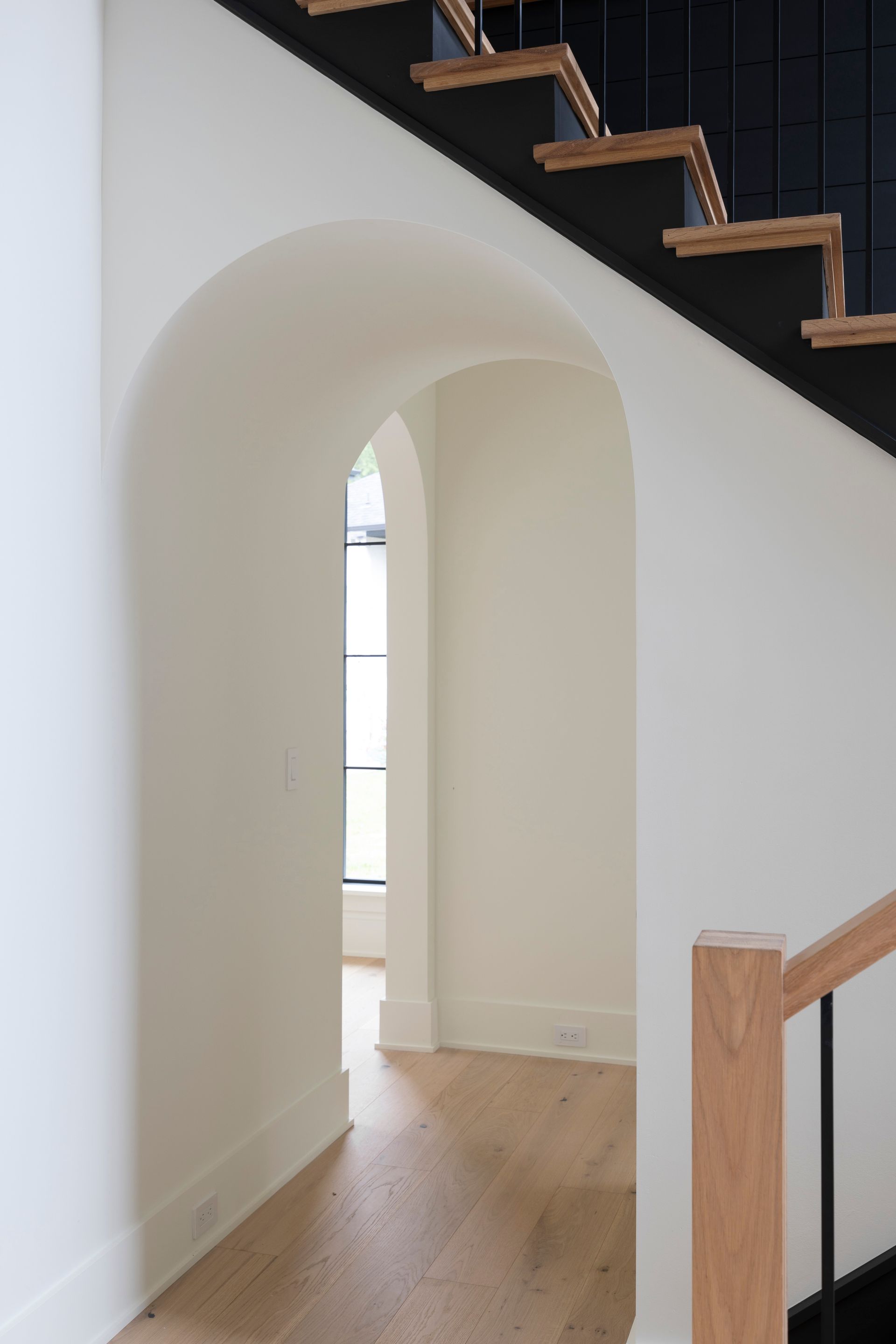 A hallway with a staircase leading up to the second floor