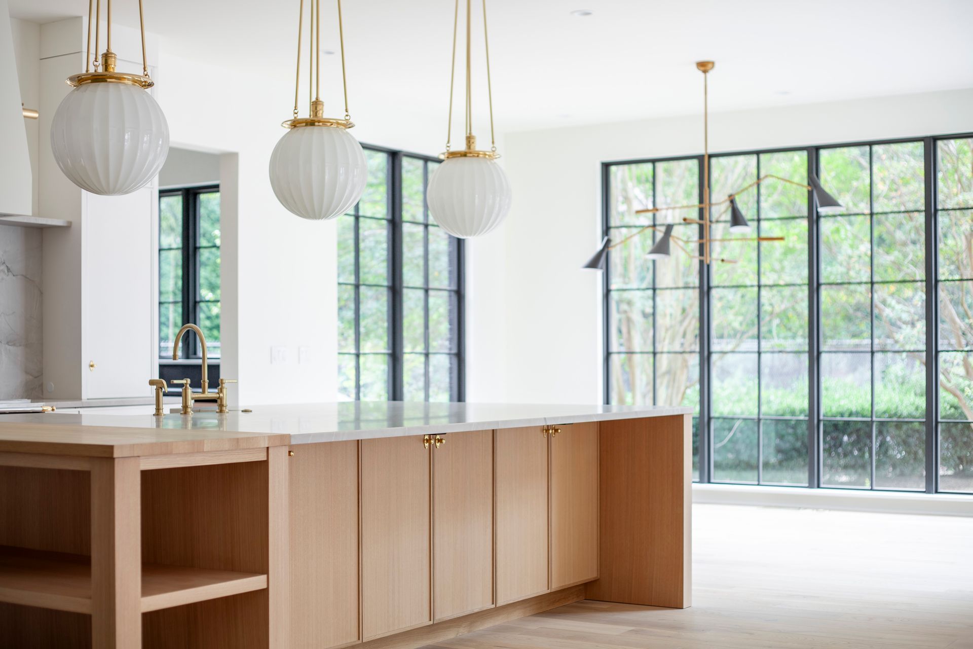 A kitchen with a large island and lots of windows.