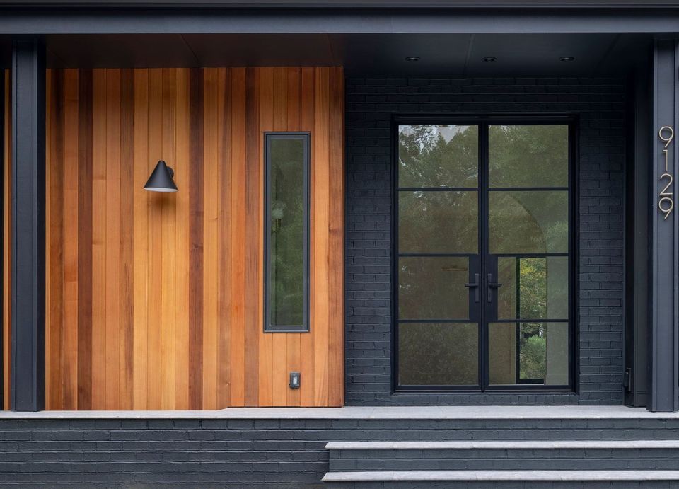 a transitional house with gray brick and a covered front porch