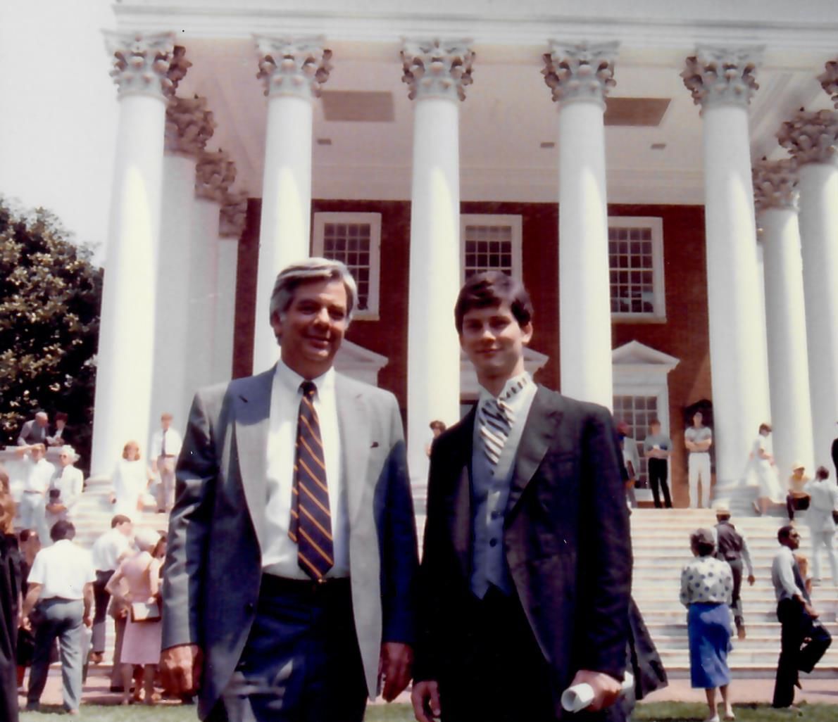 two men standing in front of a building with columns