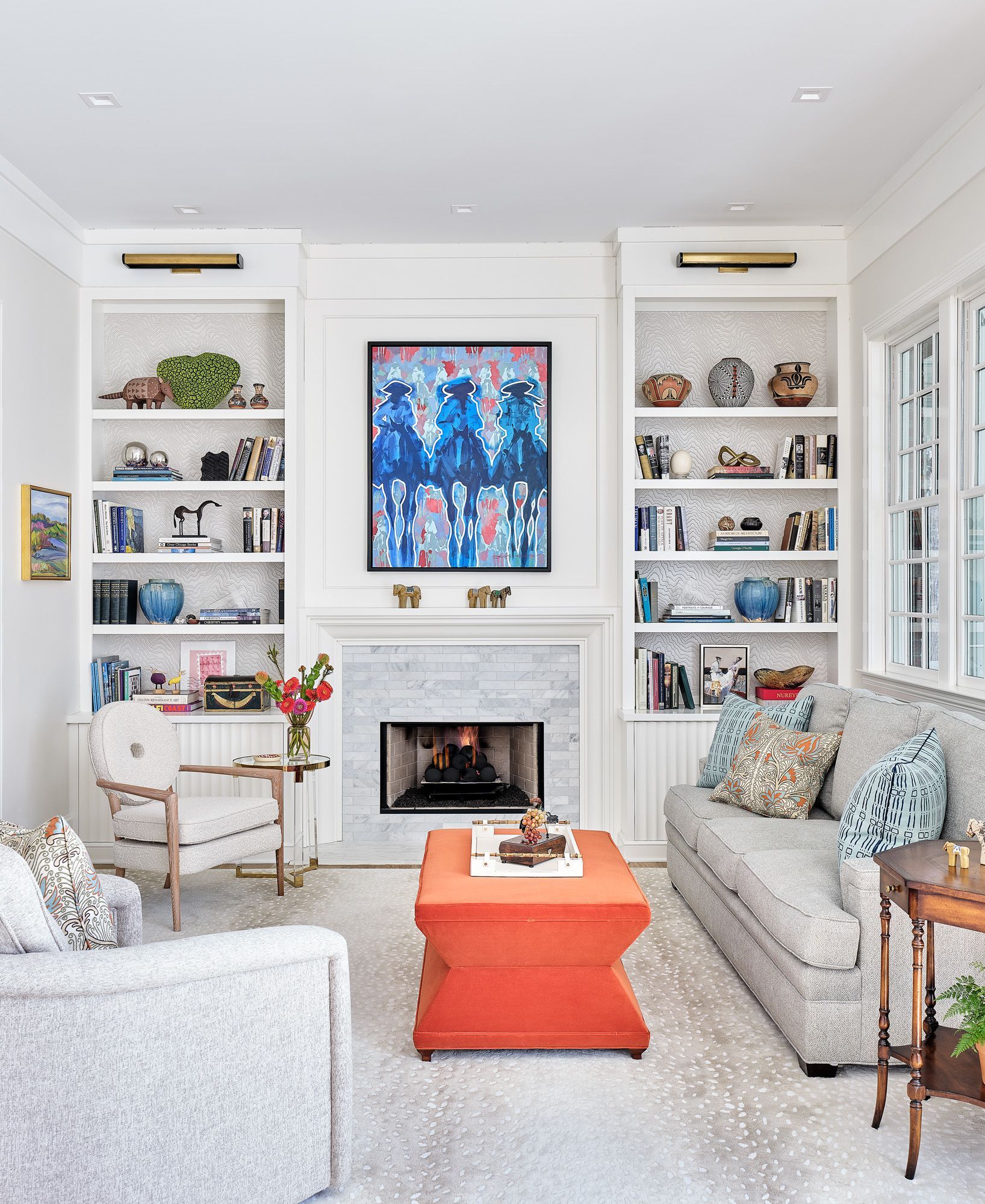 A living room with a couch , chair , coffee table and fireplace.