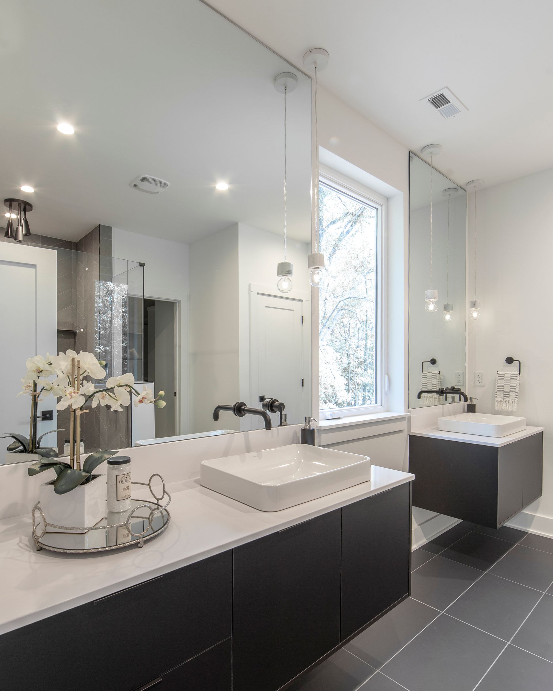 A bathroom with two sinks and a large mirror