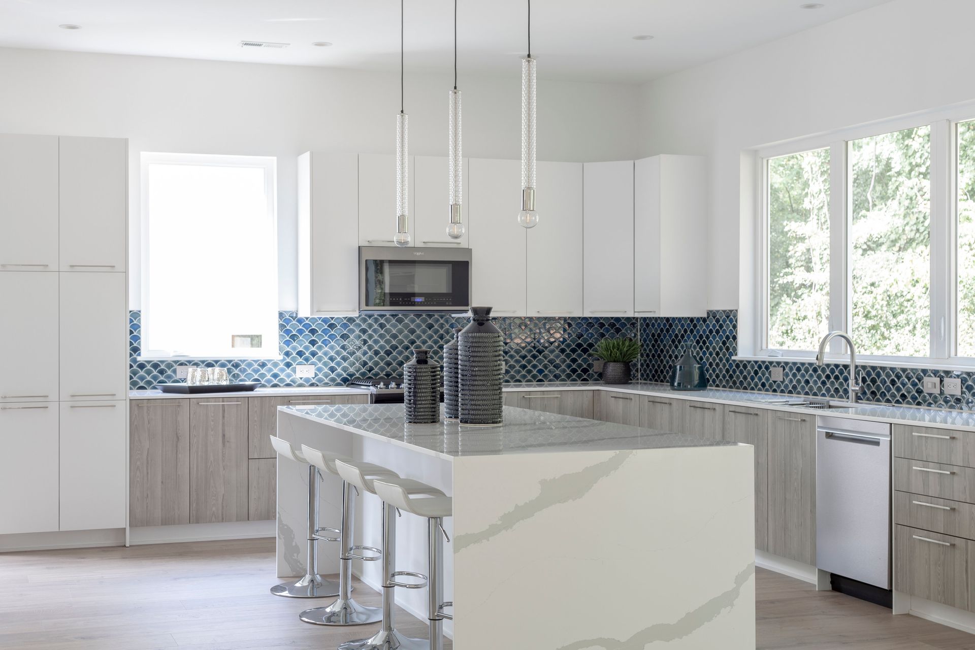 A kitchen with white cabinets and a large island in the middle.