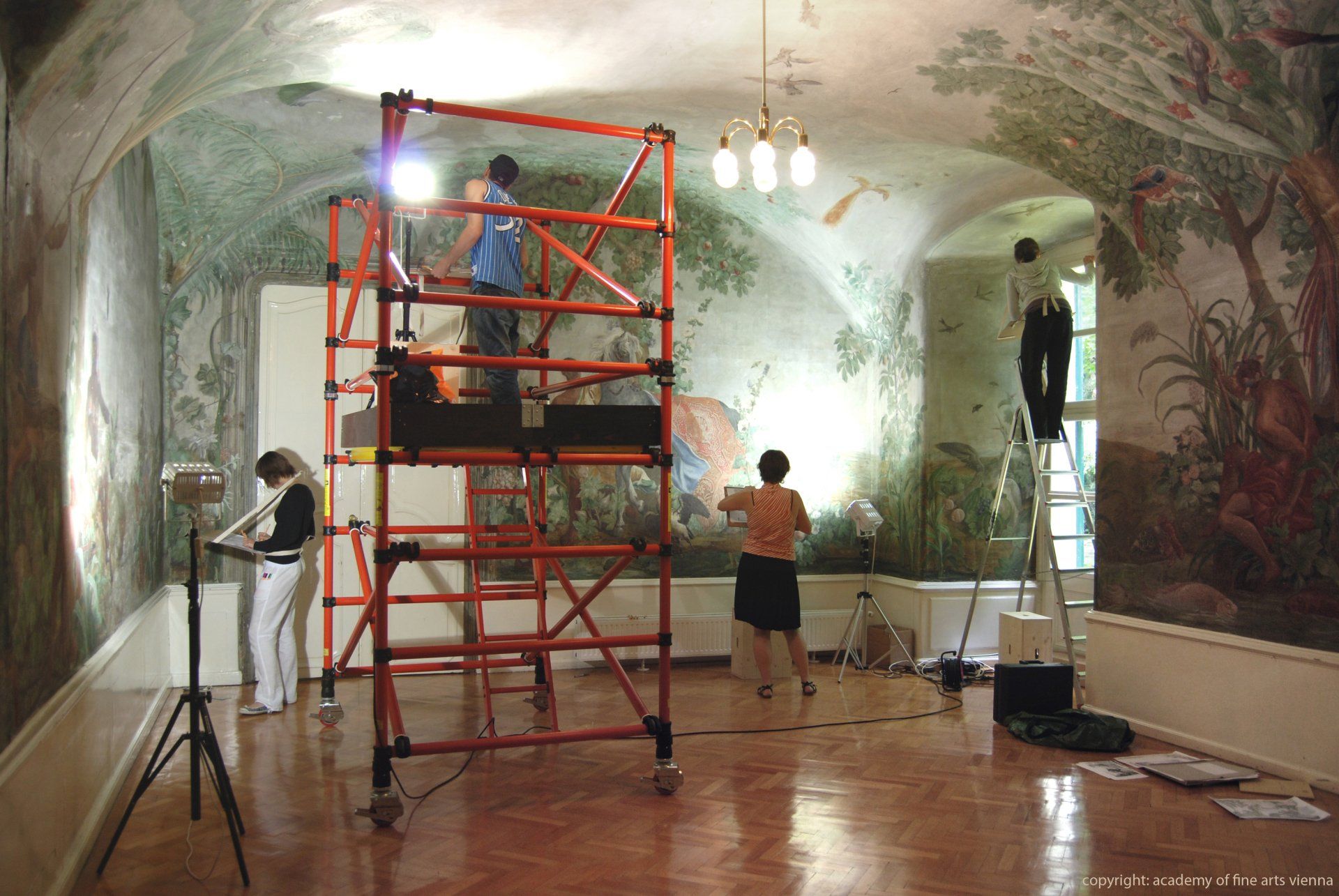 A group of people standing on scaffolding in a room