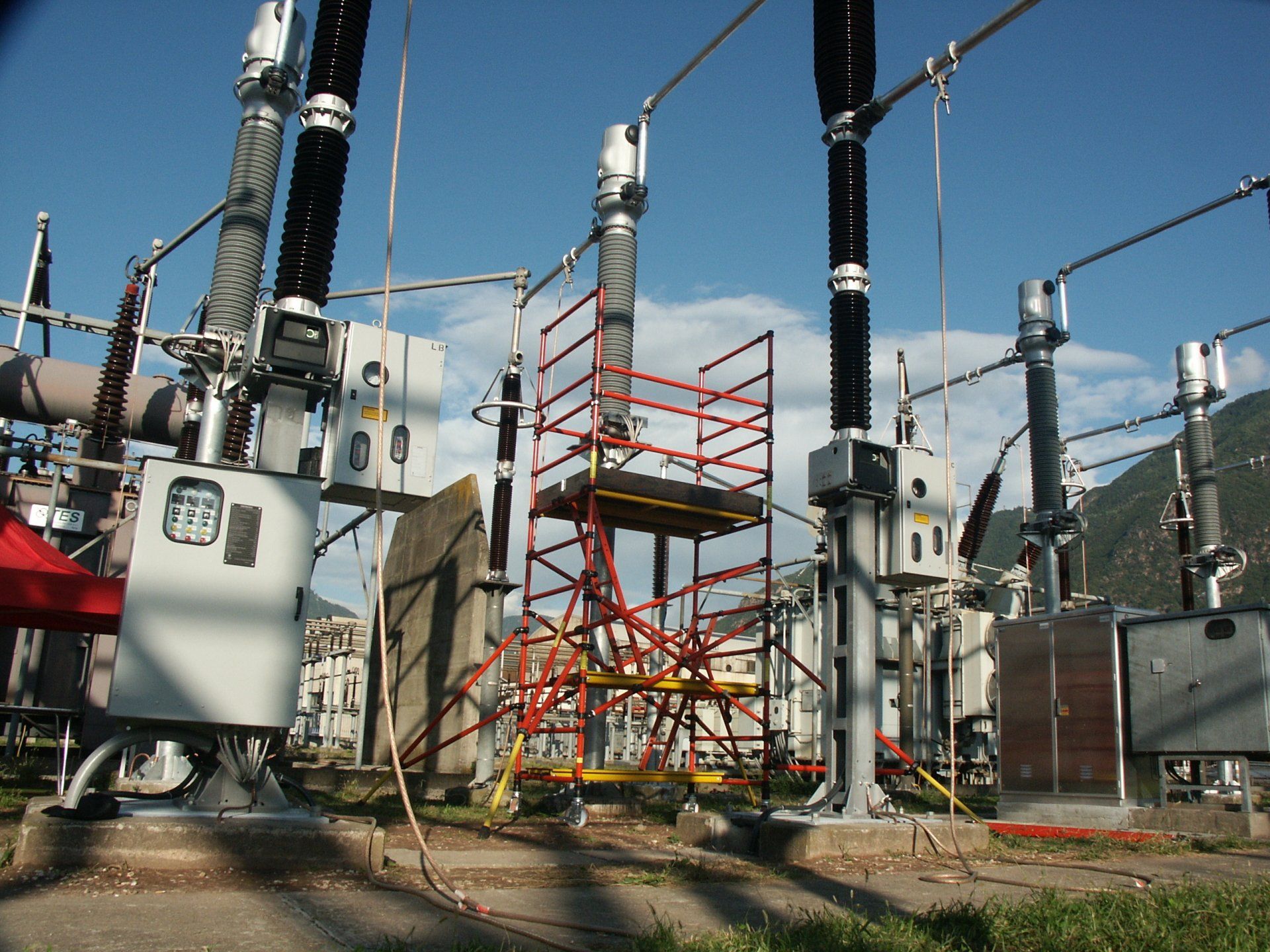 A red and yellow scaffolding is in front of a power station