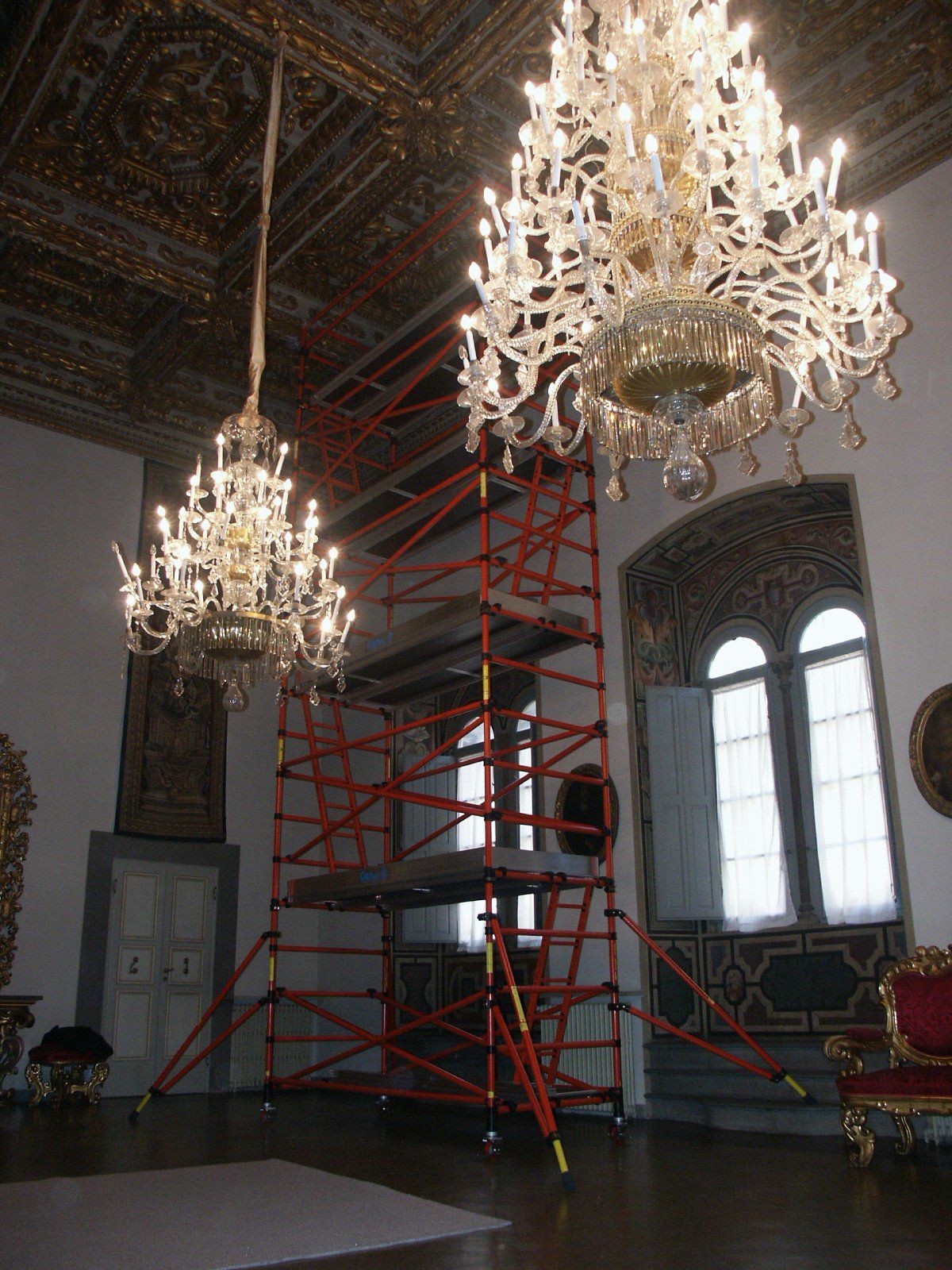 A large room with scaffolding and chandeliers hanging from the ceiling