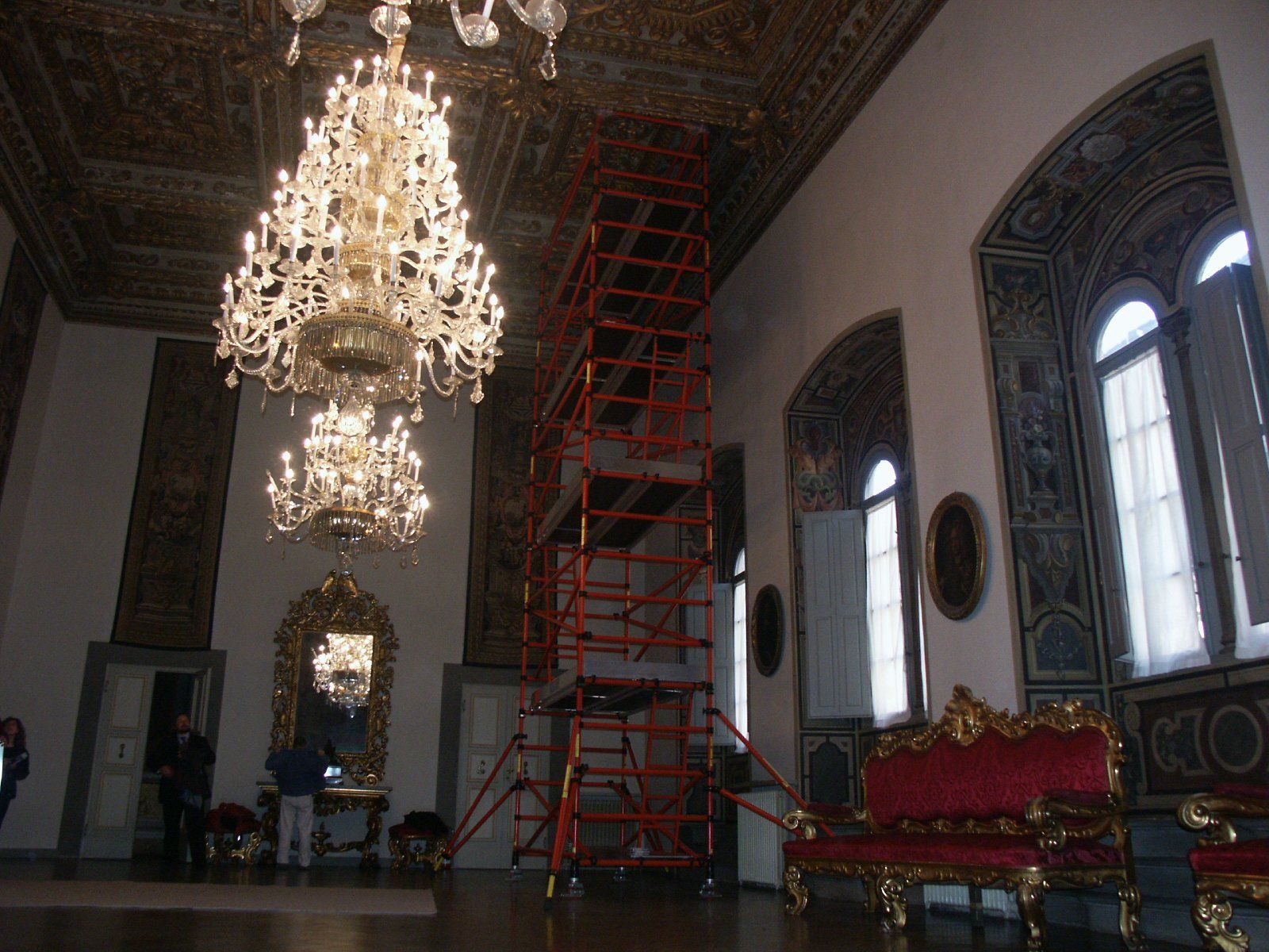 A large room with a chandelier and a red couch