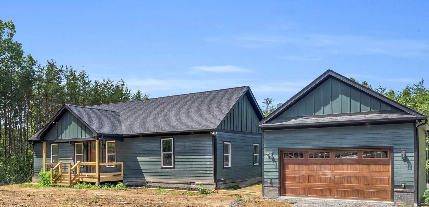 Spacious living room with wood floors, fireplace, white sofa, and an open doorway.