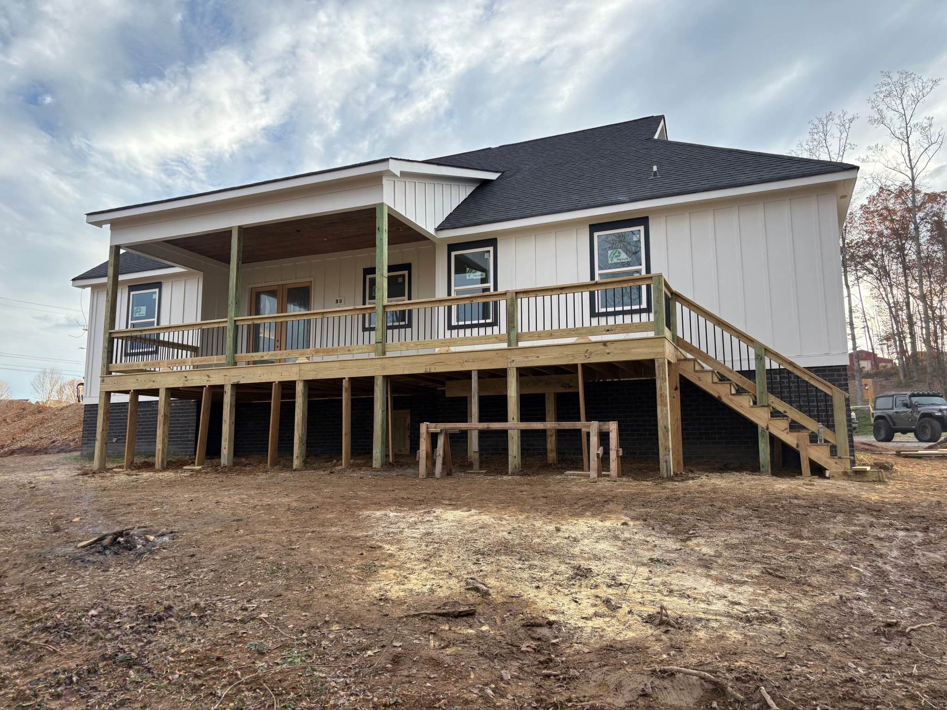 The back of a house with a large deck and stairs.