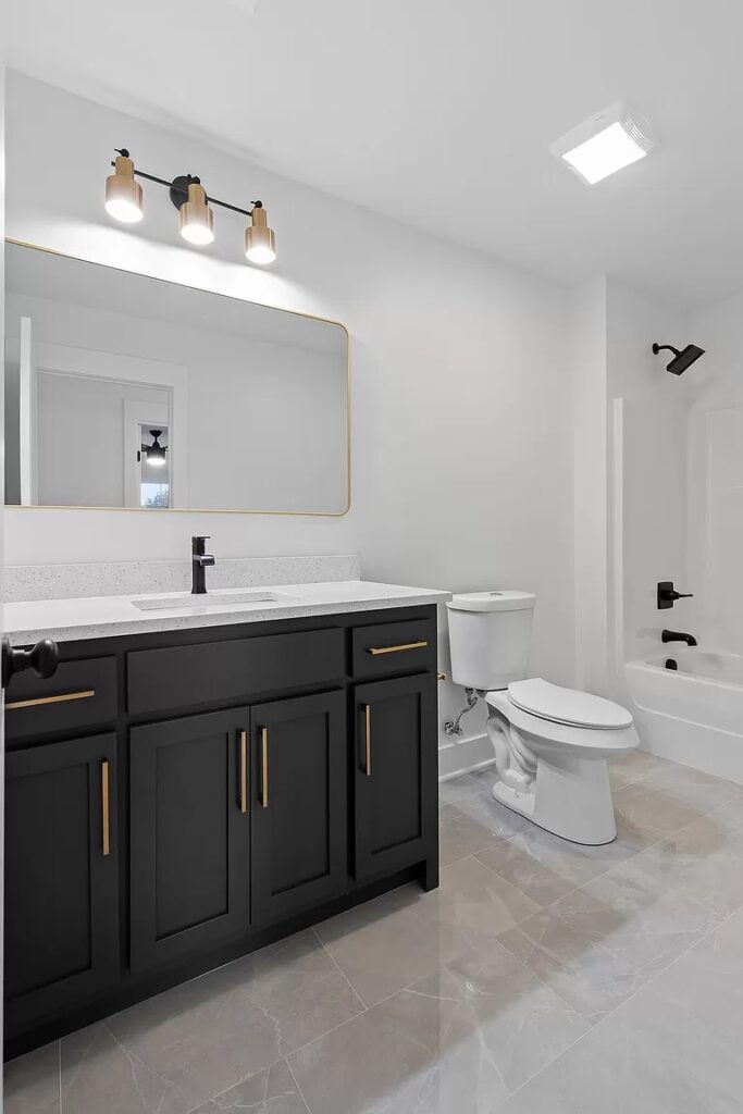 A bathroom with a toilet , sink , mirror and bathtub.