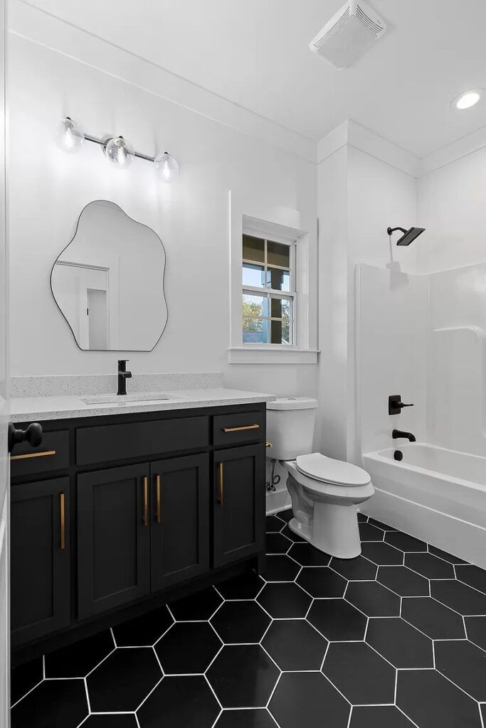 A bathroom with a toilet , sink , mirror and bathtub.