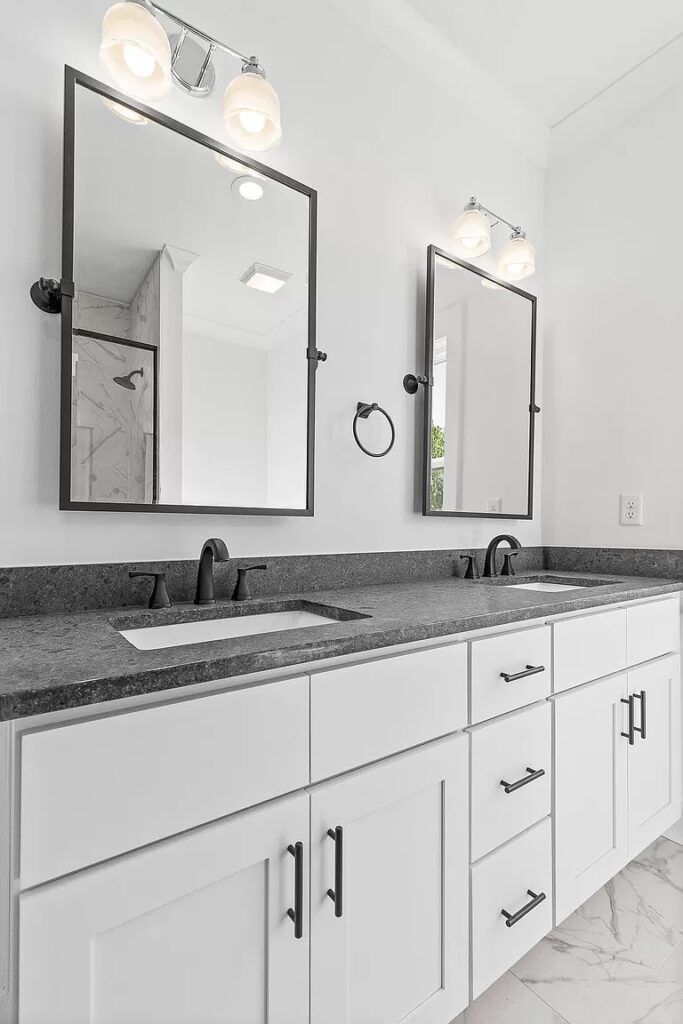 A bathroom with two sinks and two mirrors.