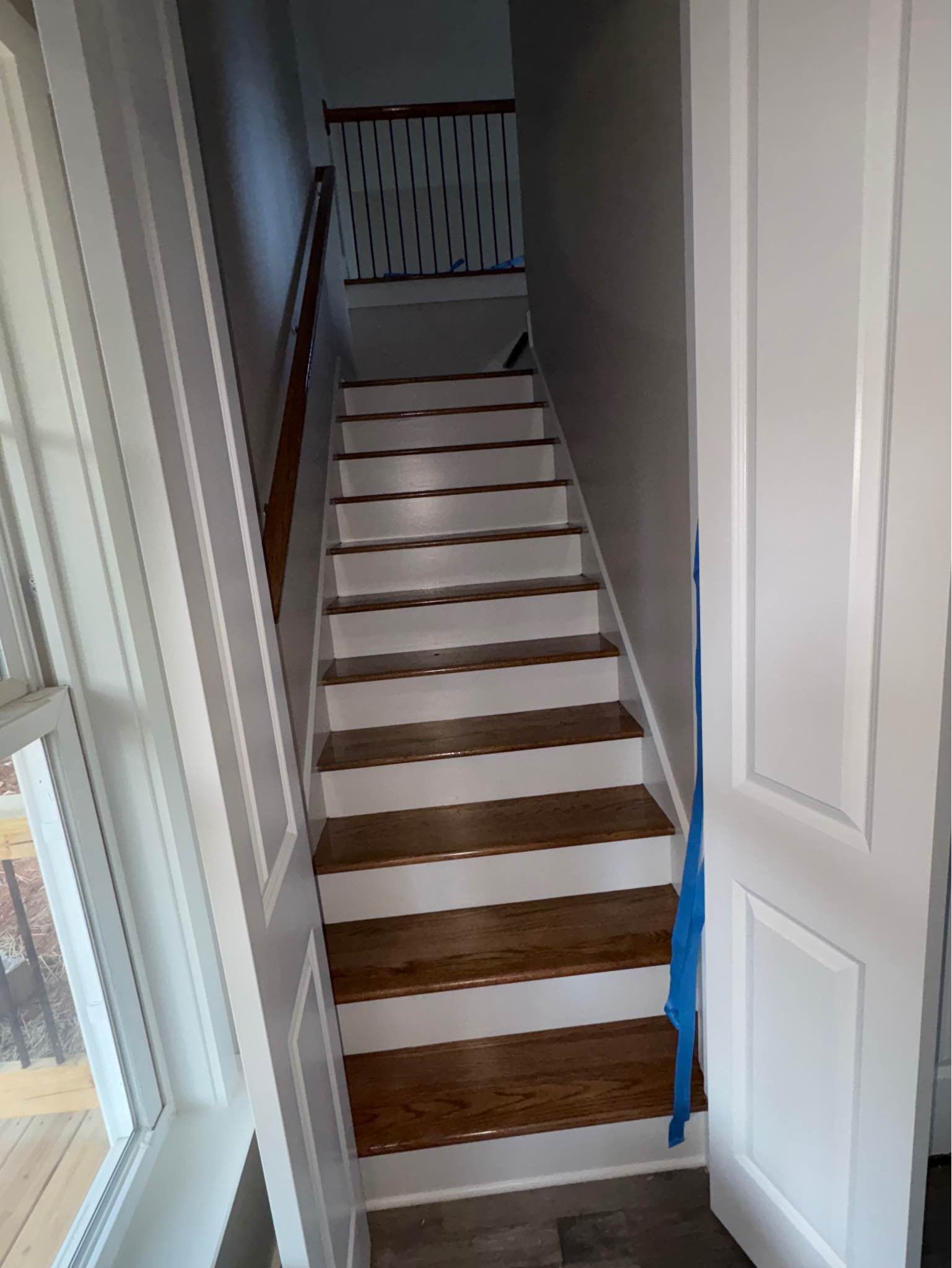 A staircase with white steps and wooden steps in a house.