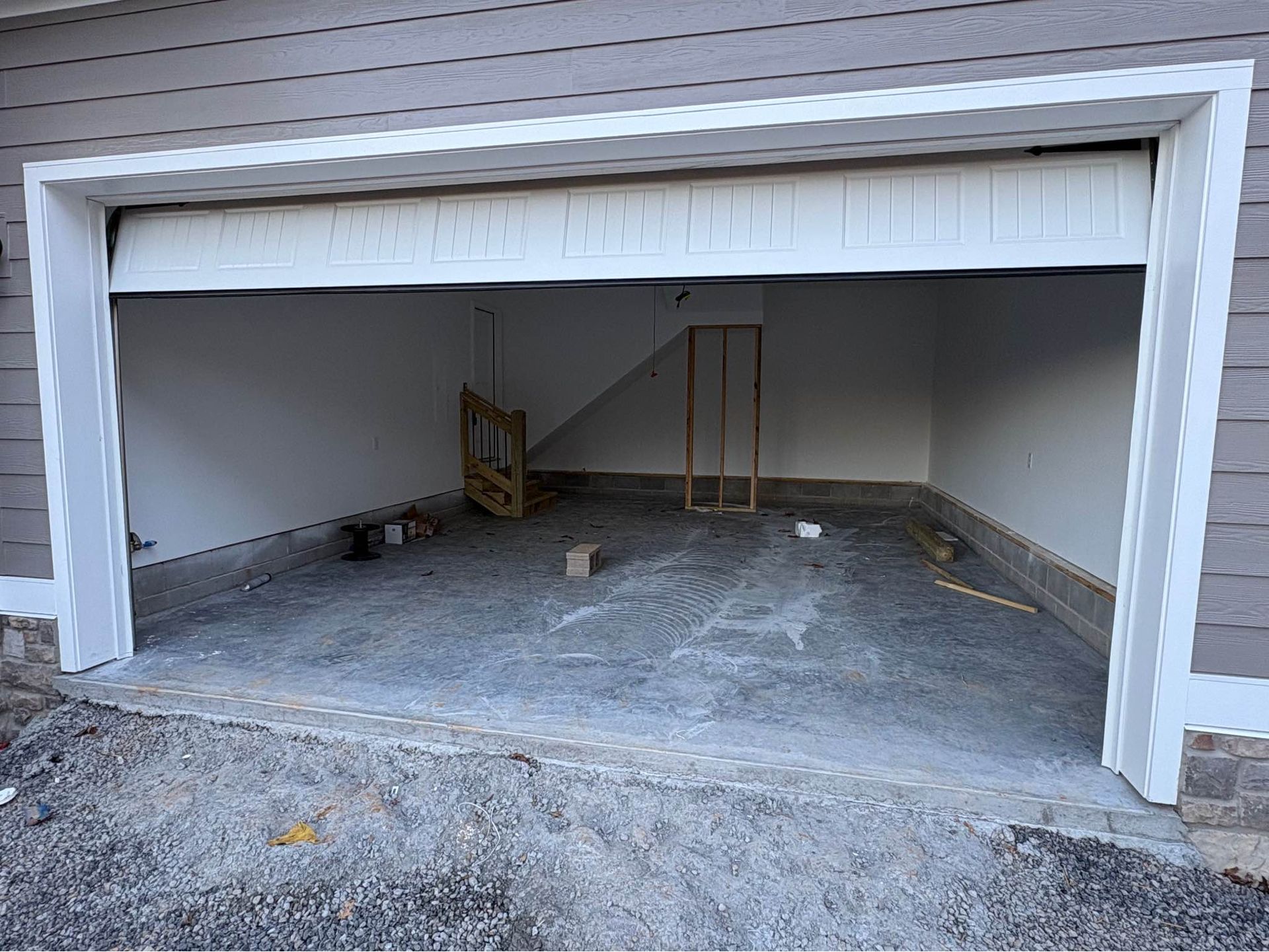 An empty garage with a white door and a concrete floor