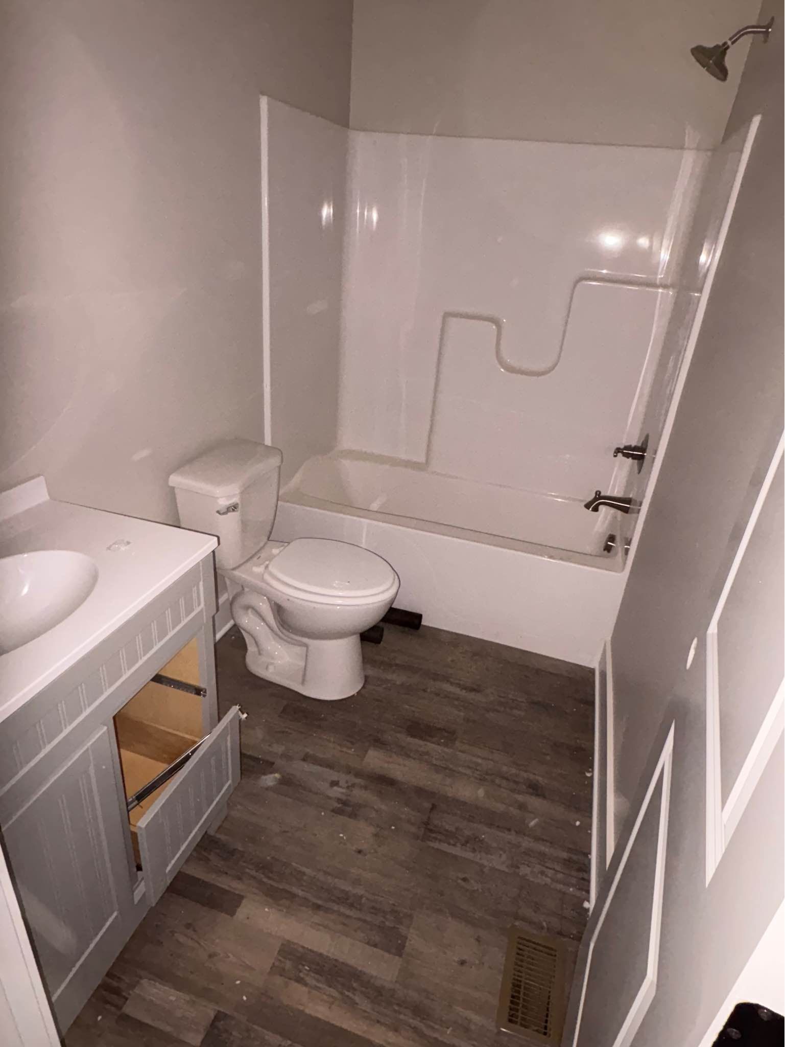 A bathroom with a toilet , sink and bathtub.