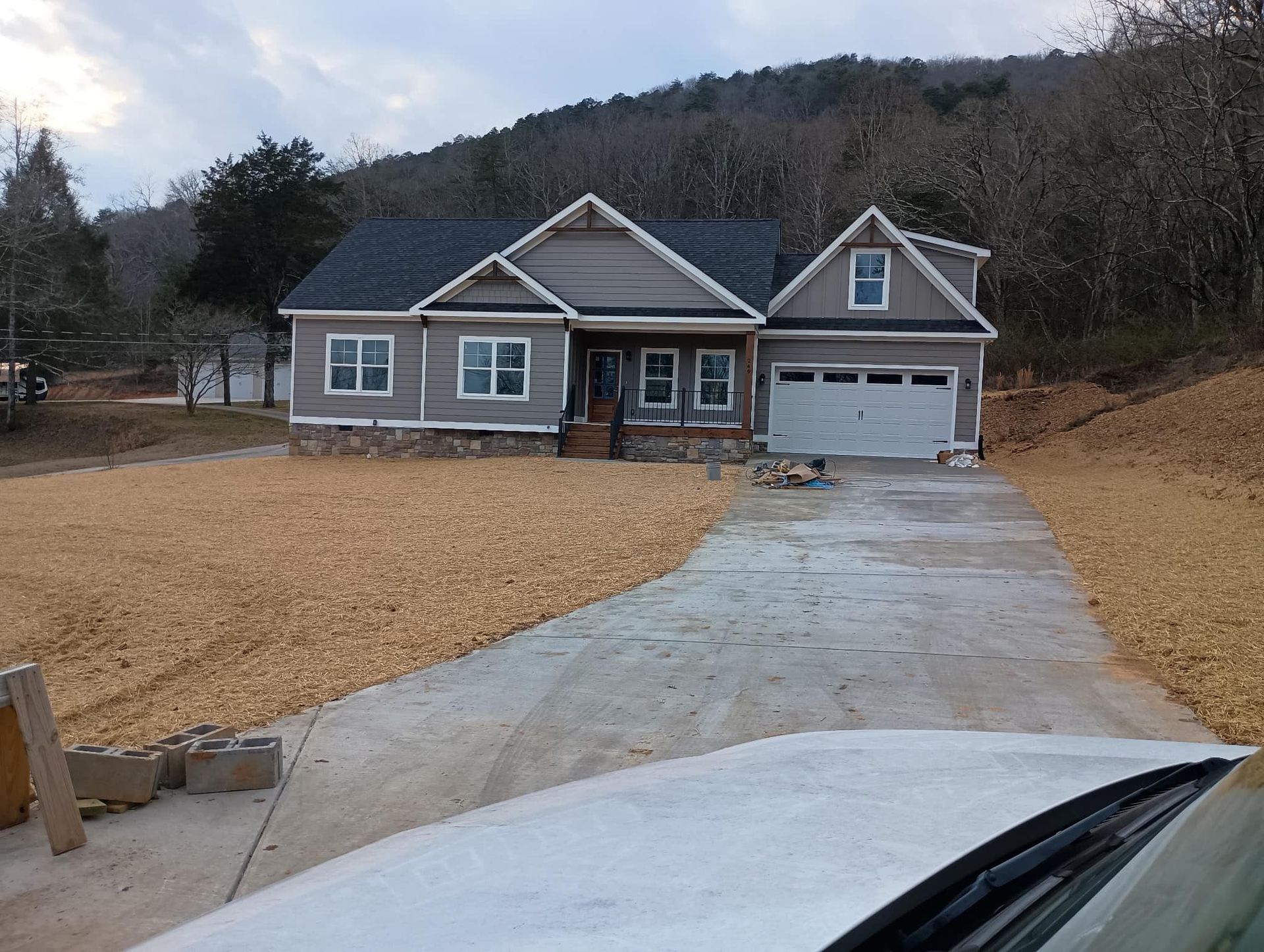 A white car is parked in front of a house