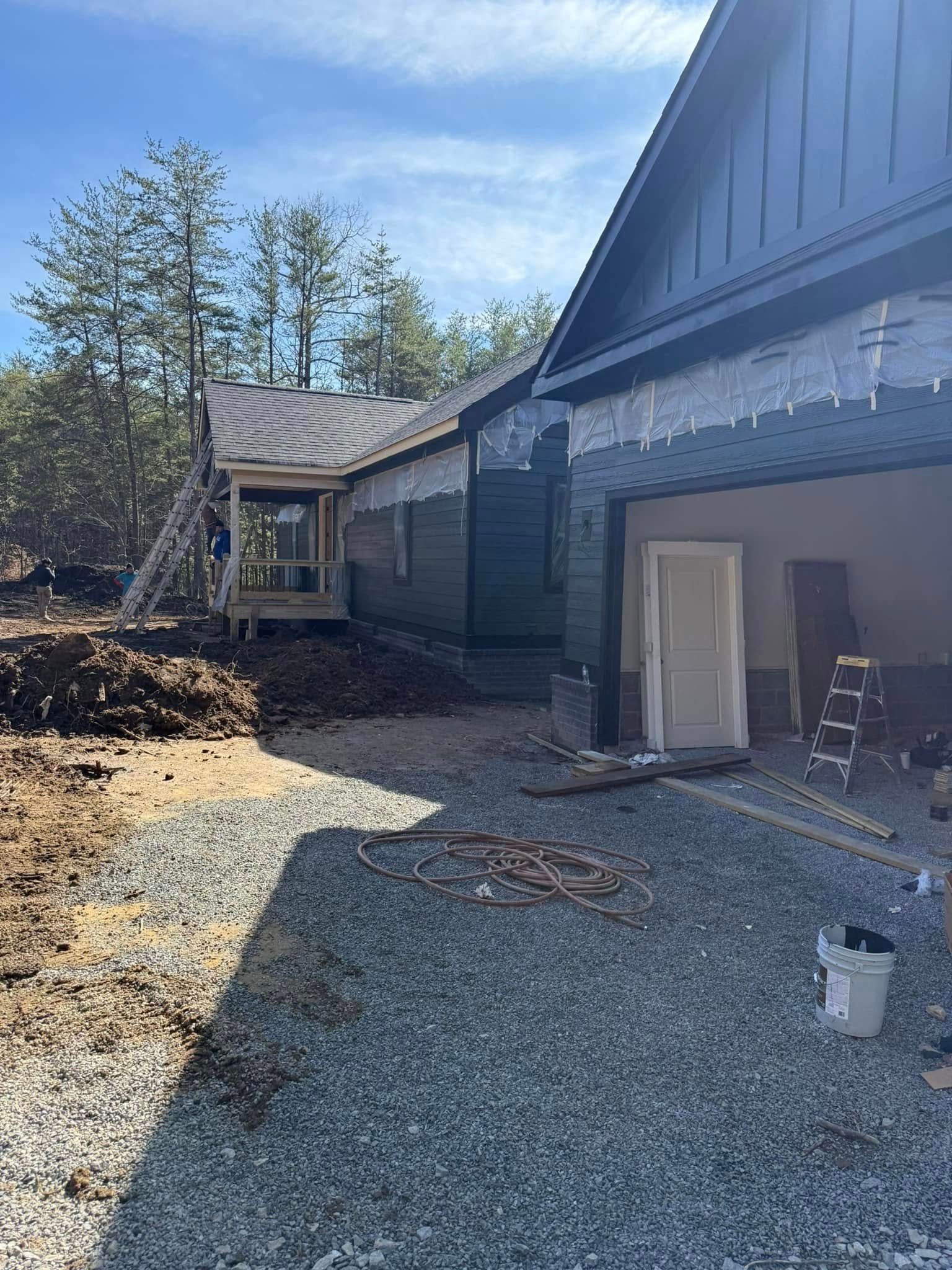 A house is being built next to a gravel driveway.