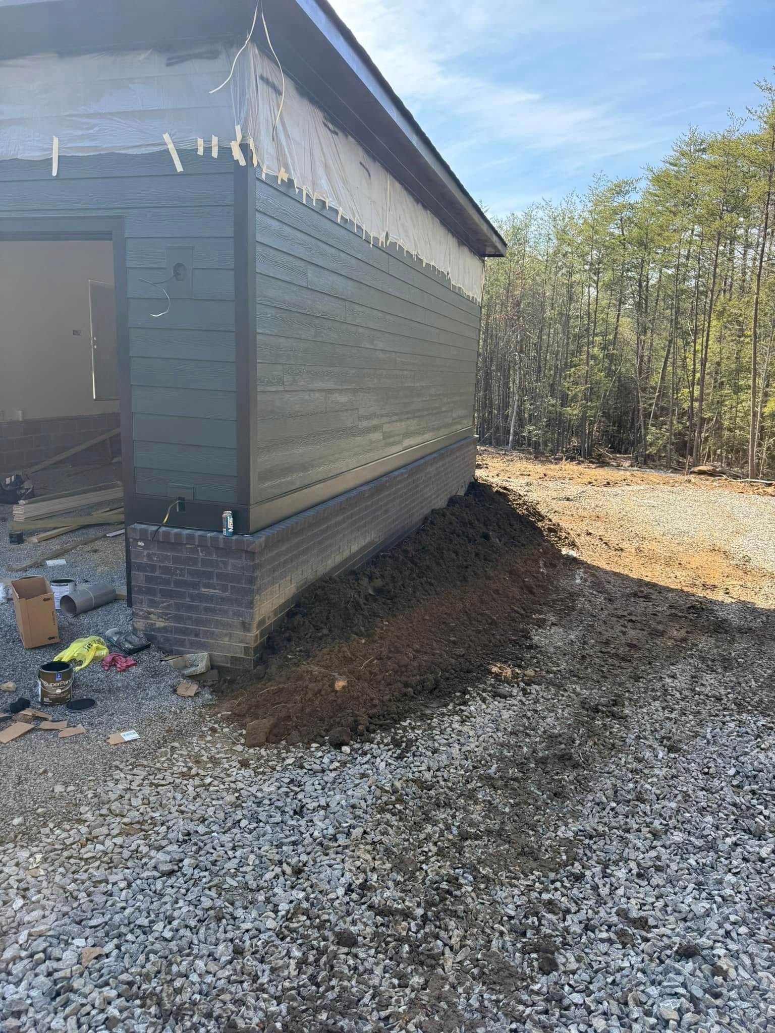 A house is being built next to a pile of gravel.