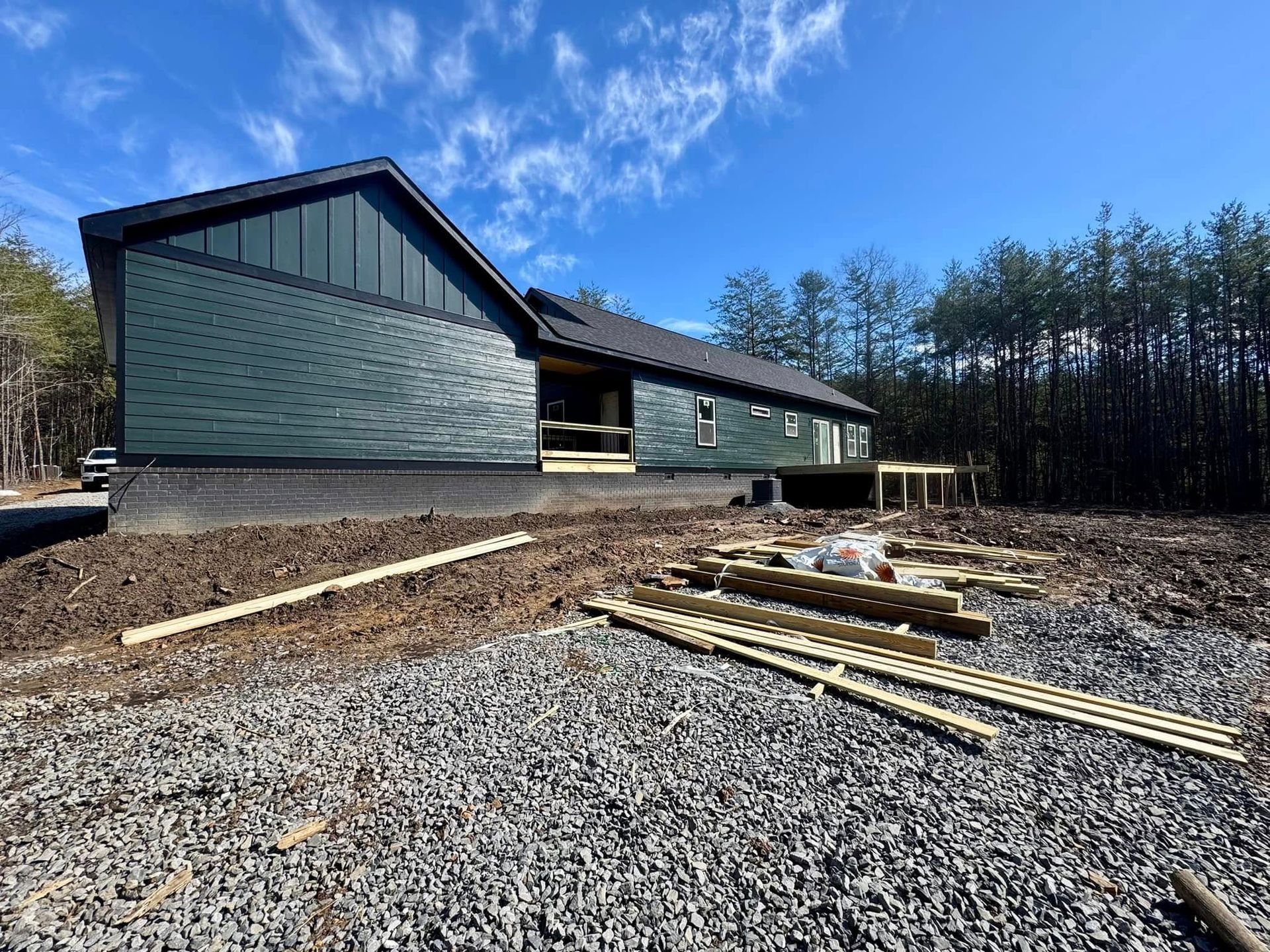A large house is being built in the middle of a dirt field.