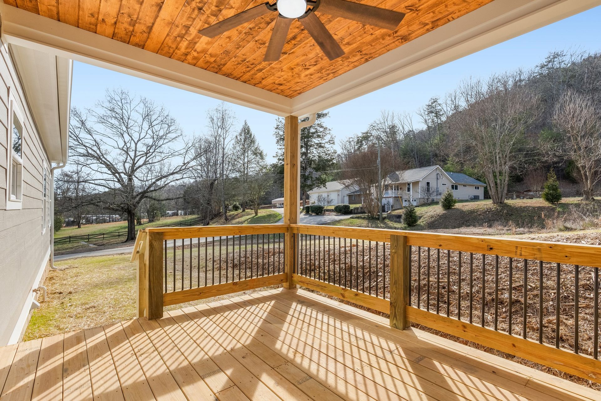 There is a ceiling fan on the porch of a house.