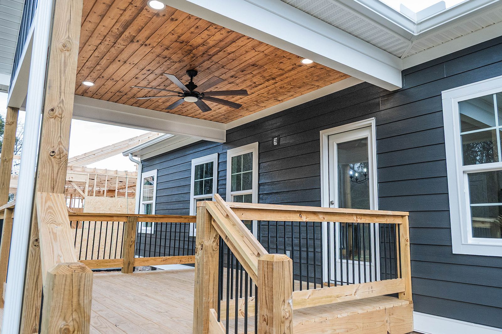 There is a ceiling fan on the porch of a house.
