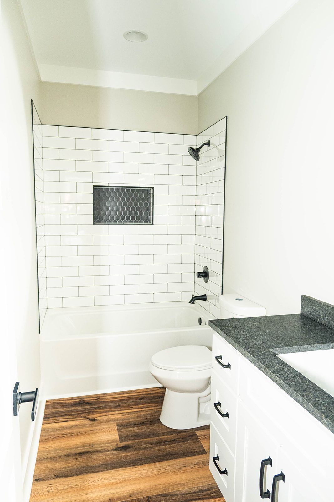 A bathroom with a toilet , sink , bathtub and shower.