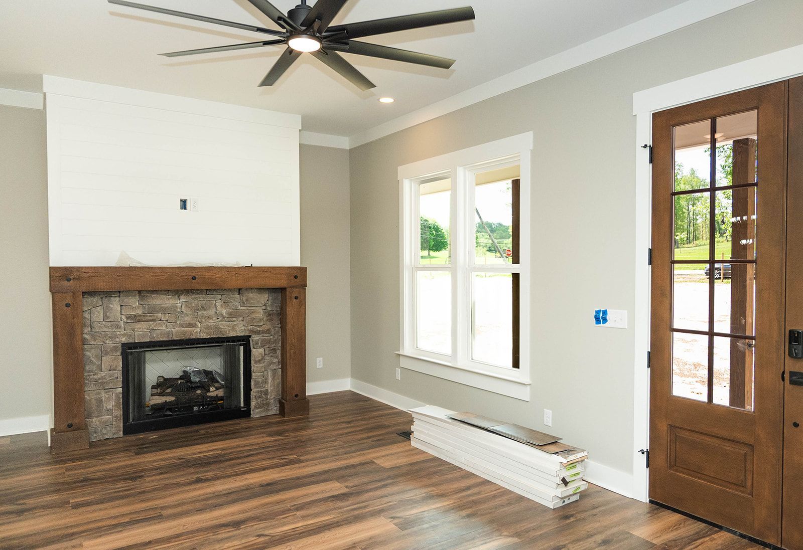 A living room with a fireplace and a ceiling fan.