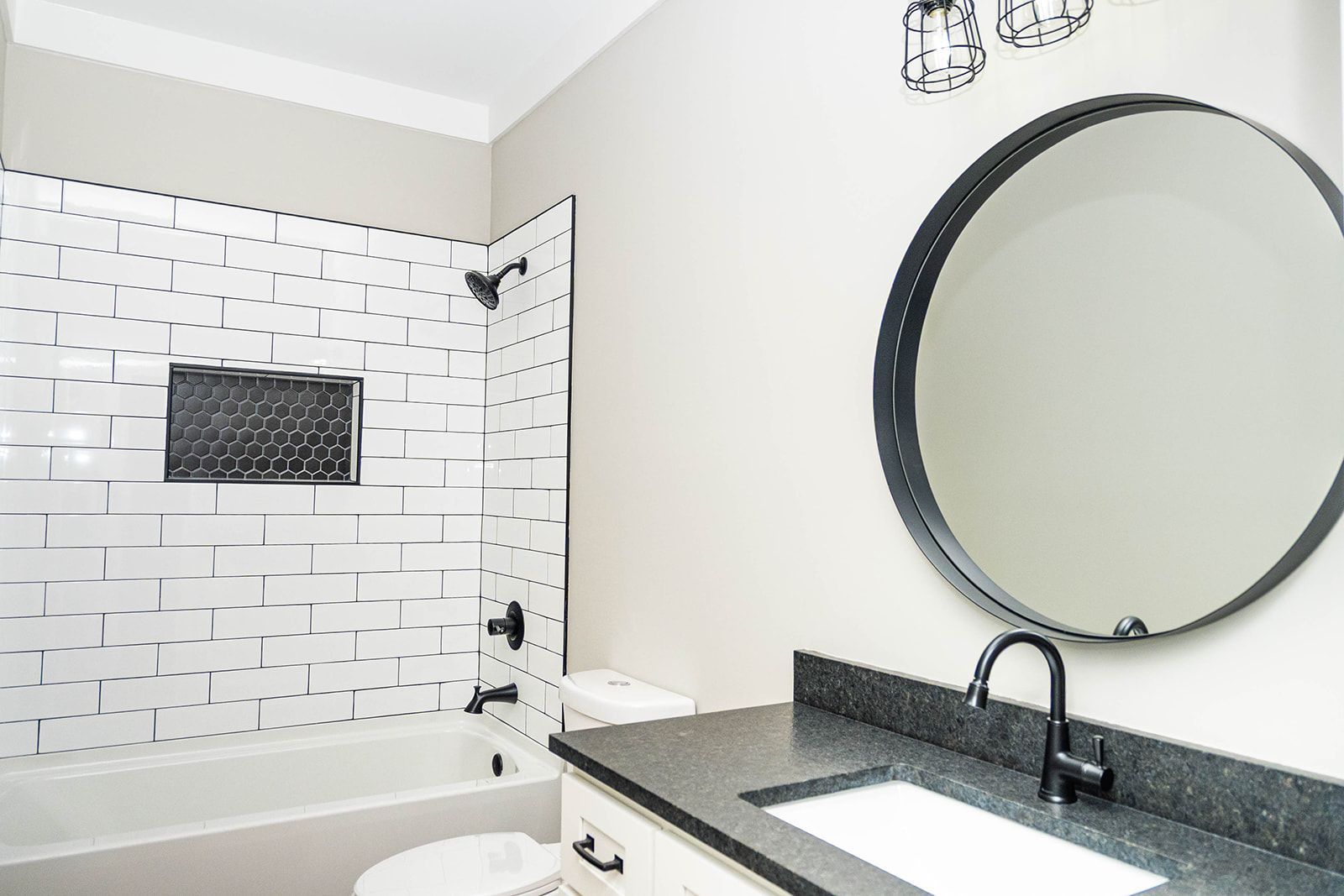A bathroom with a toilet , sink , and mirror.